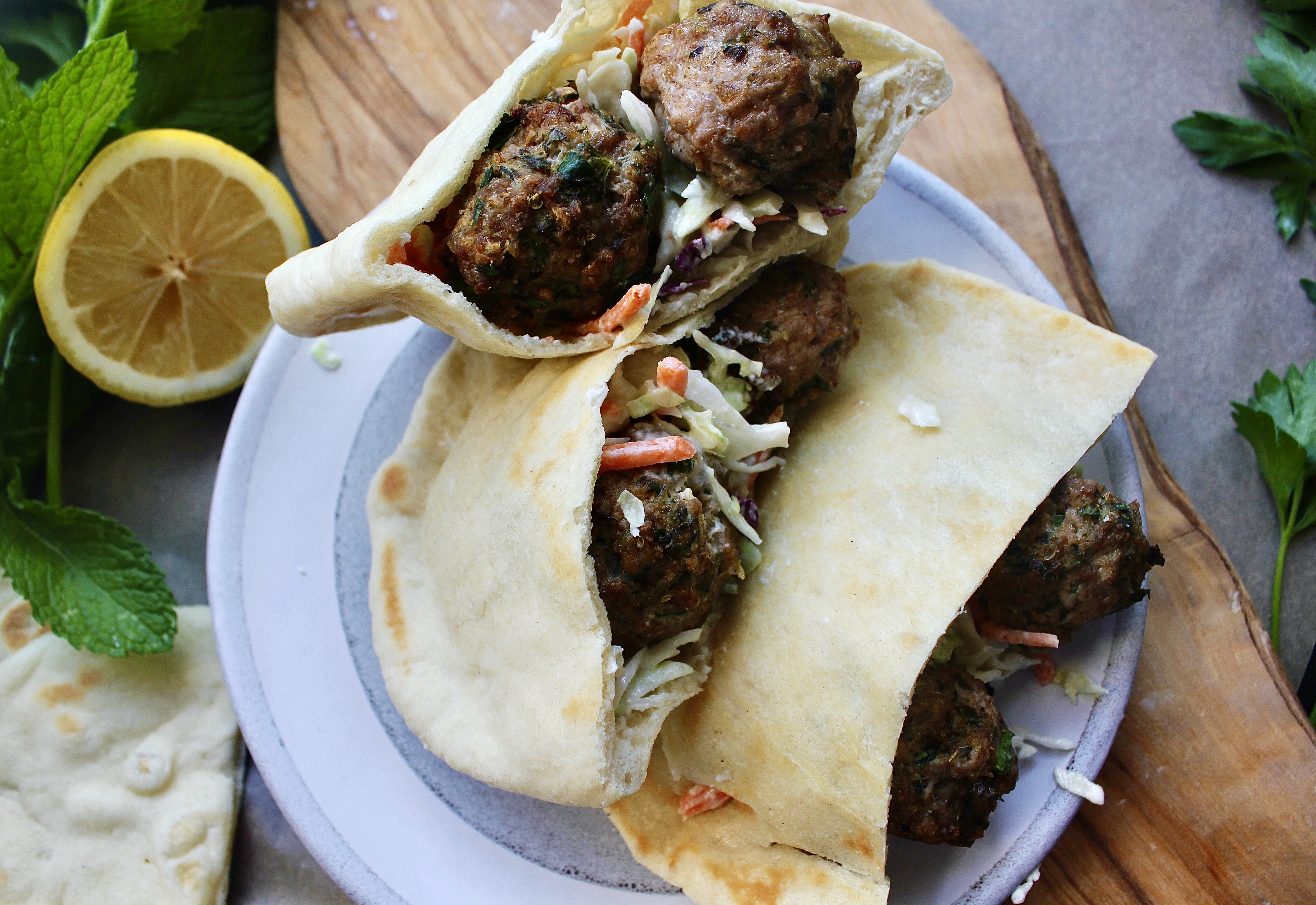 Super simple Greek Meatballs and a tangy whipped feta slaw all tucked into a warm pita: this Lemon Meatball Pitas with Tahini Feta Slaw are a crowd pleaser!!