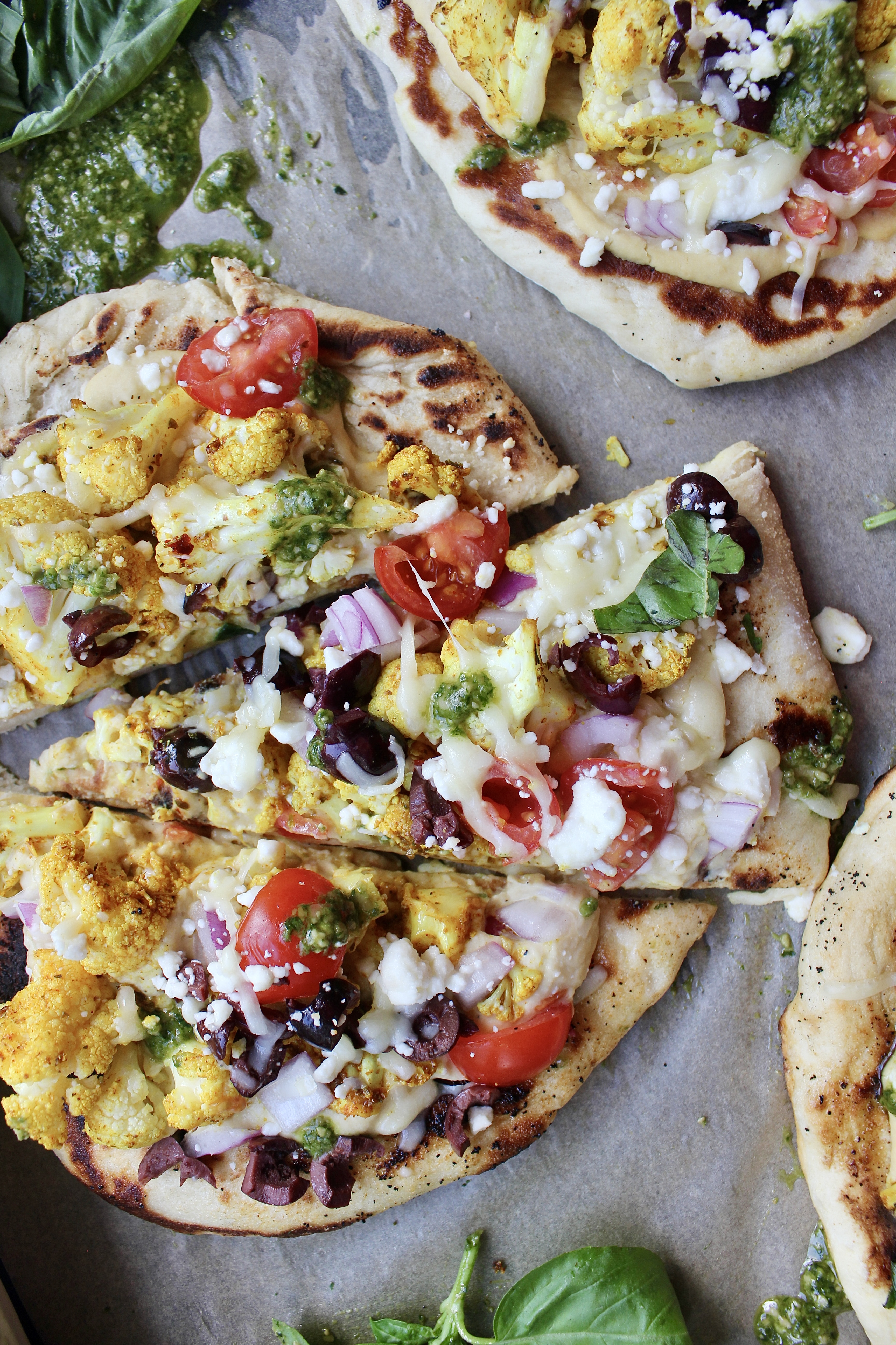Warm and fluffy homemade naan layered with your favorite hummus, roasted shawarma cauliflower, tons of Greek toppings, and all the cheese: these Homemade Cauliflower Shawarma Naan Flatbreads are everyone’s favorite! 