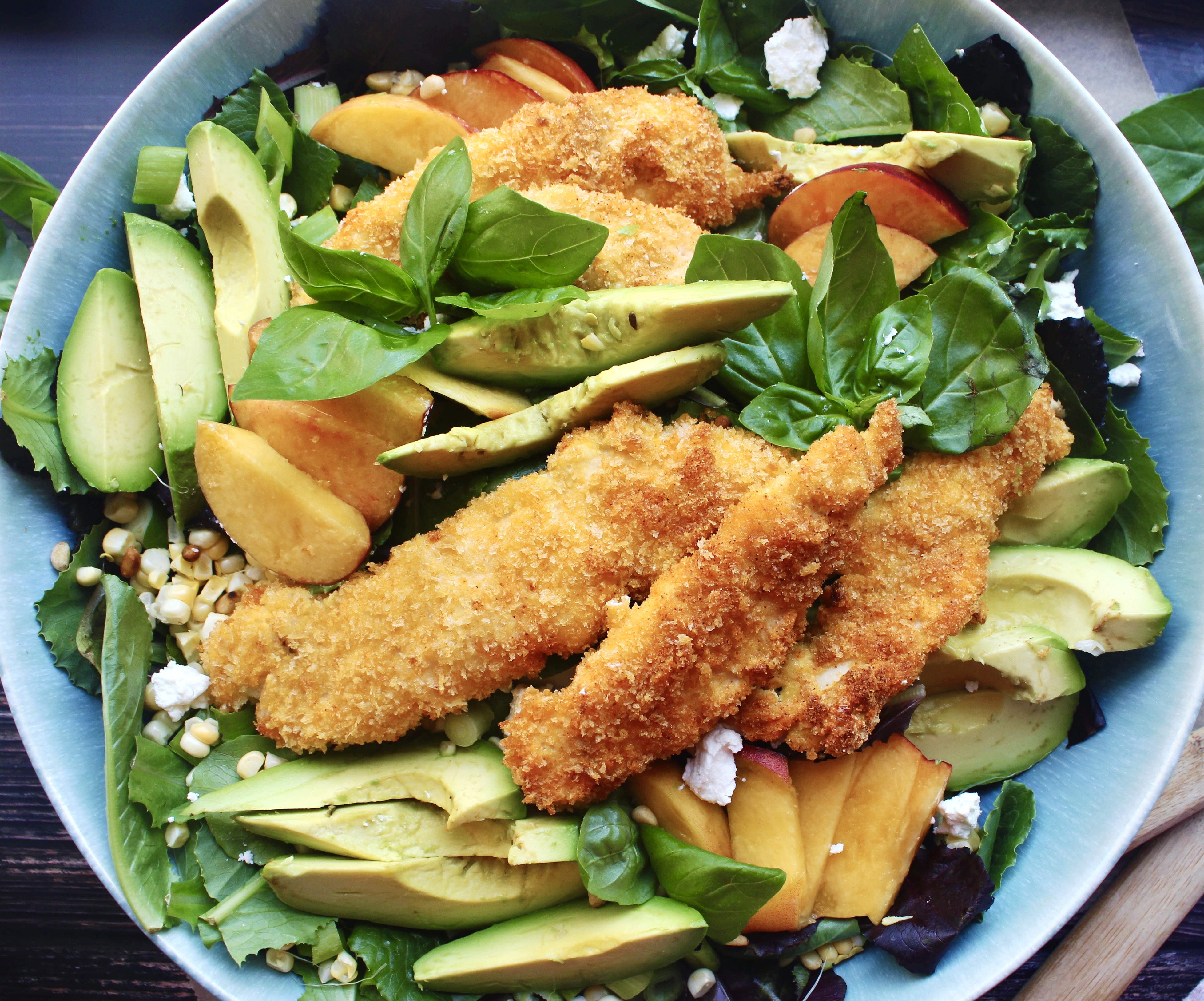 With a simple crusted chicken, all the best summer produce, a light and refreshing vinaigrette, and tons of creamy and crunchy textures, this Crispy Baked Chicken Salad with Corn, Peaches, and Basil is going to be your new favorite summer salad!