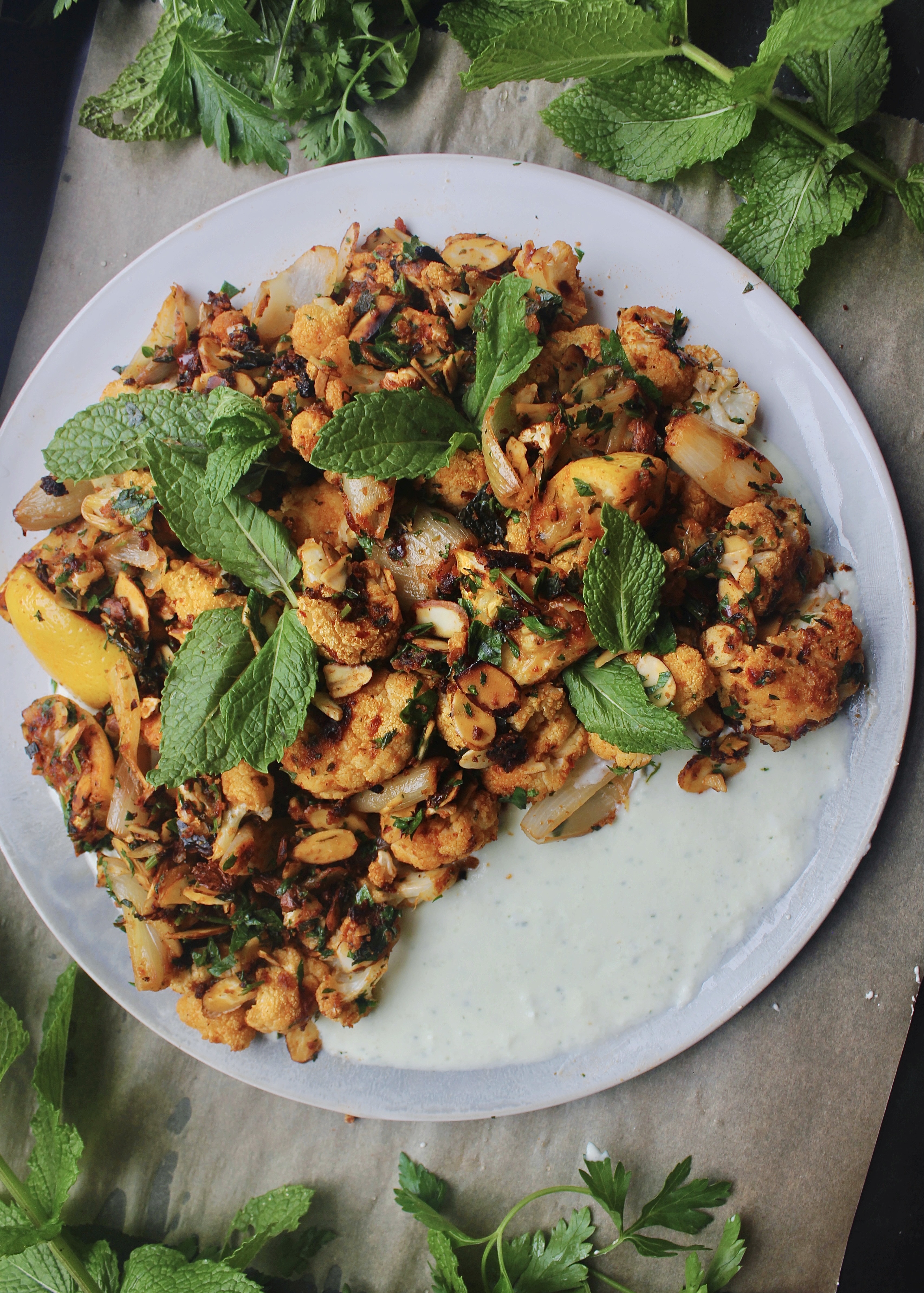 Spicy harissa and a cooling feta yogurt sauce come together in this Harissa Roasted Cauliflower with Toasted Almonds and Feta Yogurt to make the most impressive yet easy side!