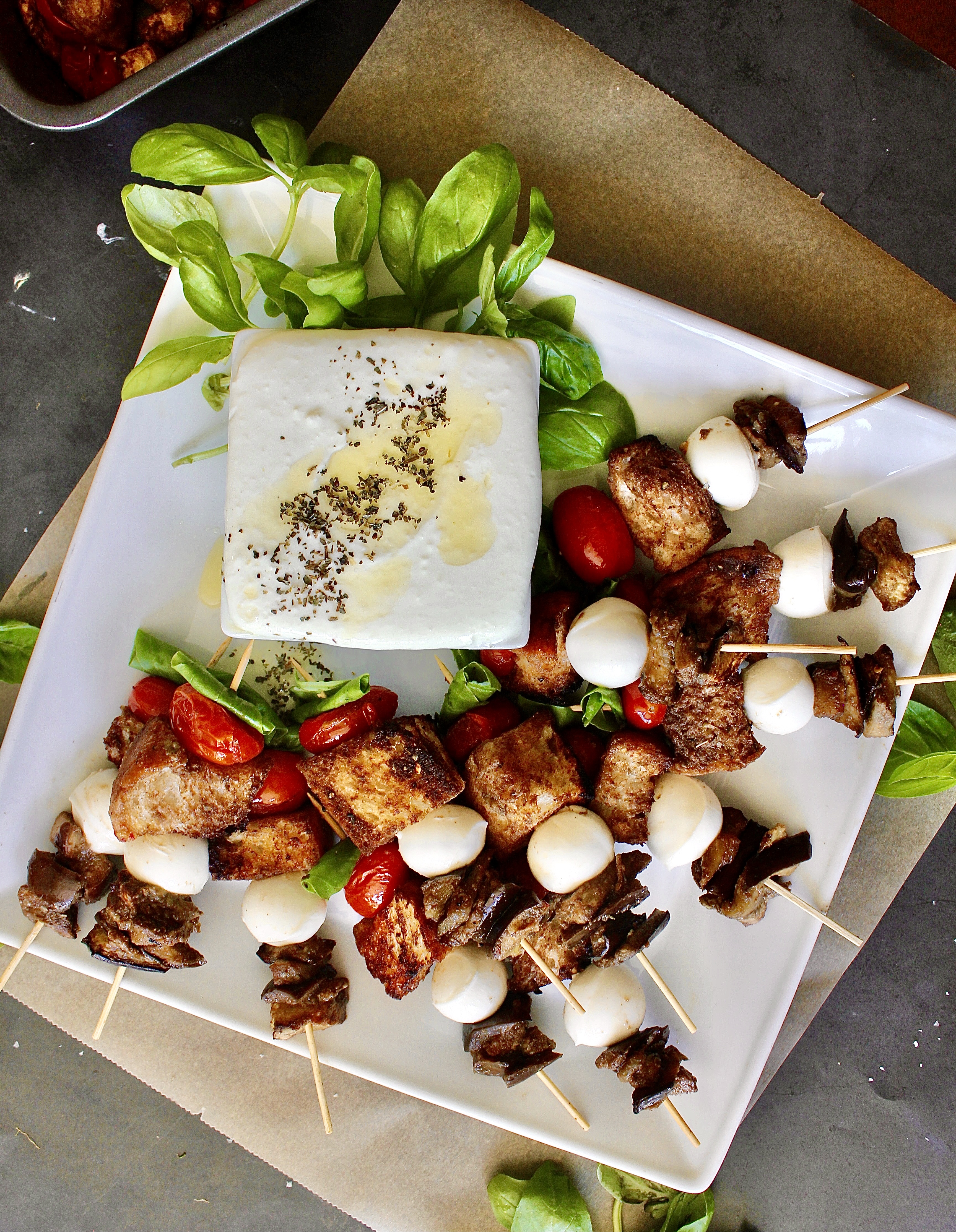 Golden ciabatta, eggplant, and tomatoes layered with fresh mozzarella and basil all on a skewer perfect for dipping into a luscious honey whipped goat cheese dip: these Roasted Vegetable Panzanella Skewers with Whipped Goat Cheese are everyone’s favorite appetizer!