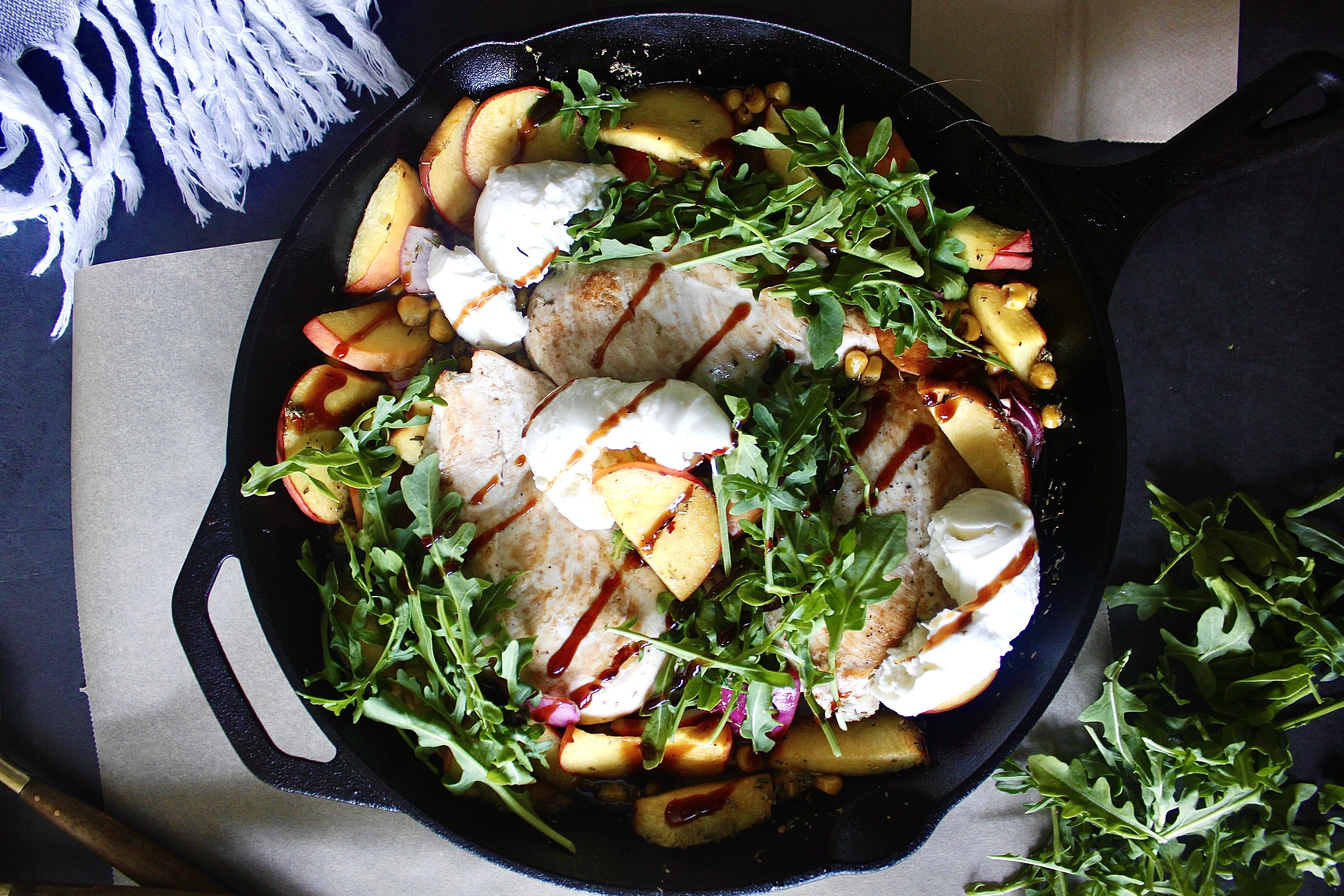 Peaches, corn, and chicken baked in luscious balsamic citrus juices all finished off with fresh arugula and creamy burrata cheese: this Summer Balsamic Chicken Skillet with Creamy Burrata is the best skillet meal!