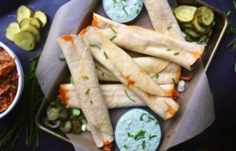 Sweet and spicy barbecue pulled chicken with caramelized onions and tons of spices all tucked into a warm, crisp oven baked tortilla: these Barbecue Chicken Taquitos with Herbed Crema are heavenly.