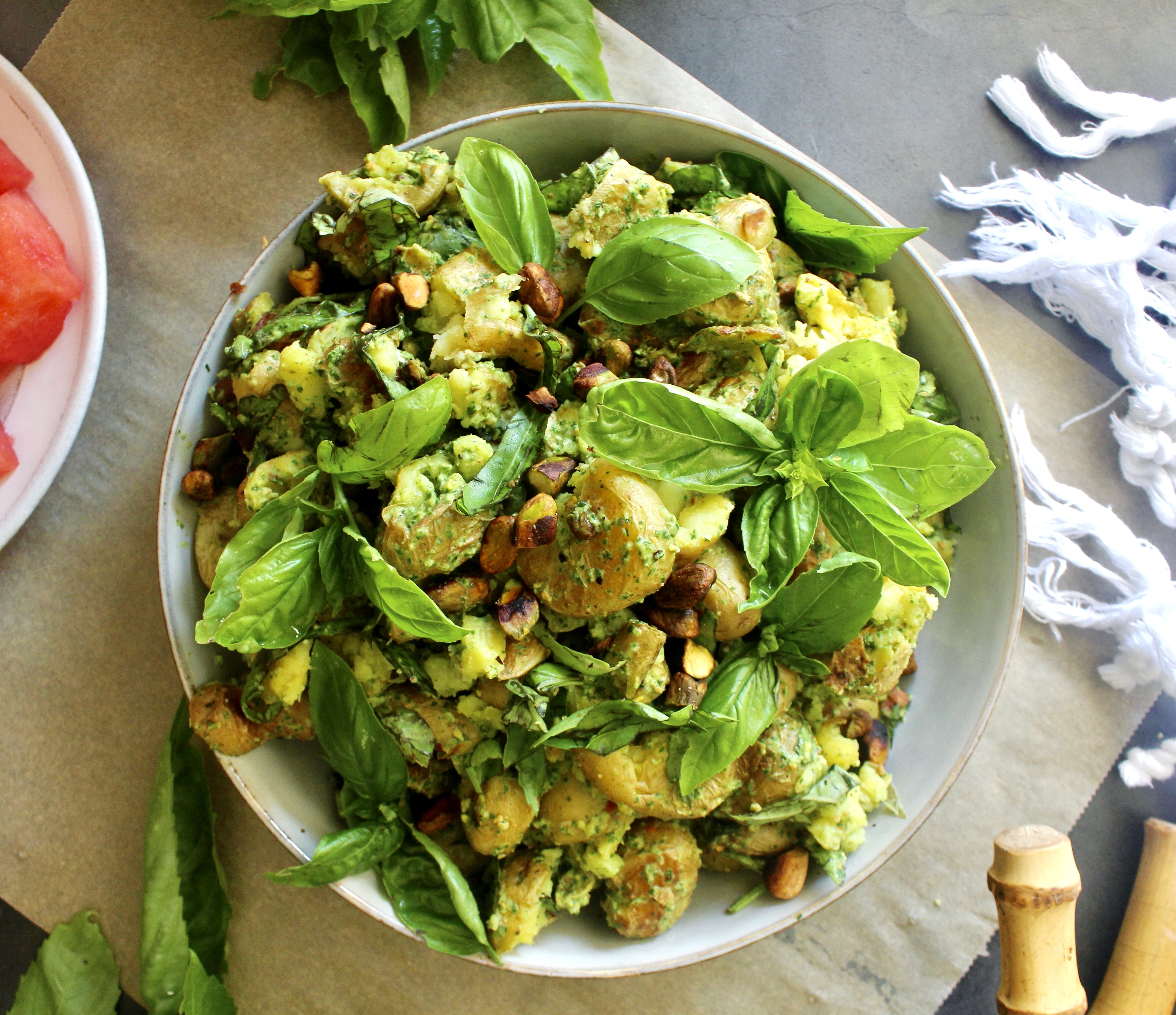 Crispy smashed baby potatoes tossed in a simple arugula pesto: This Smashed Pistachio Pesto di Rucola Potato Salad is the best summer mayo-free potato salad!