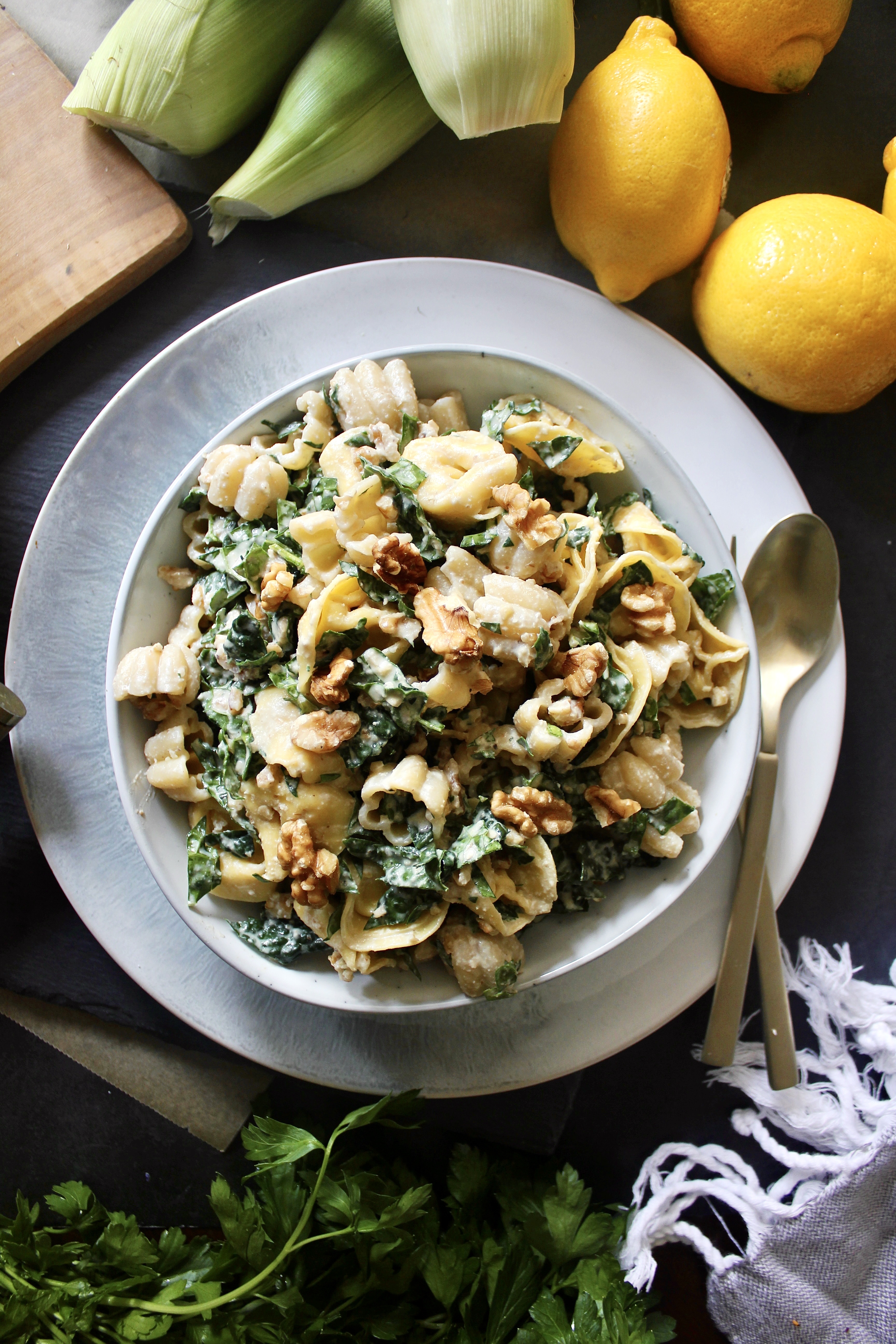 A creamy crunchy walnut parmesan dressing massaged into kale and tossed with chilled cheese tortellini: this Parmesan Kale Tortellini Pasta Salad makes for the best summer side!!