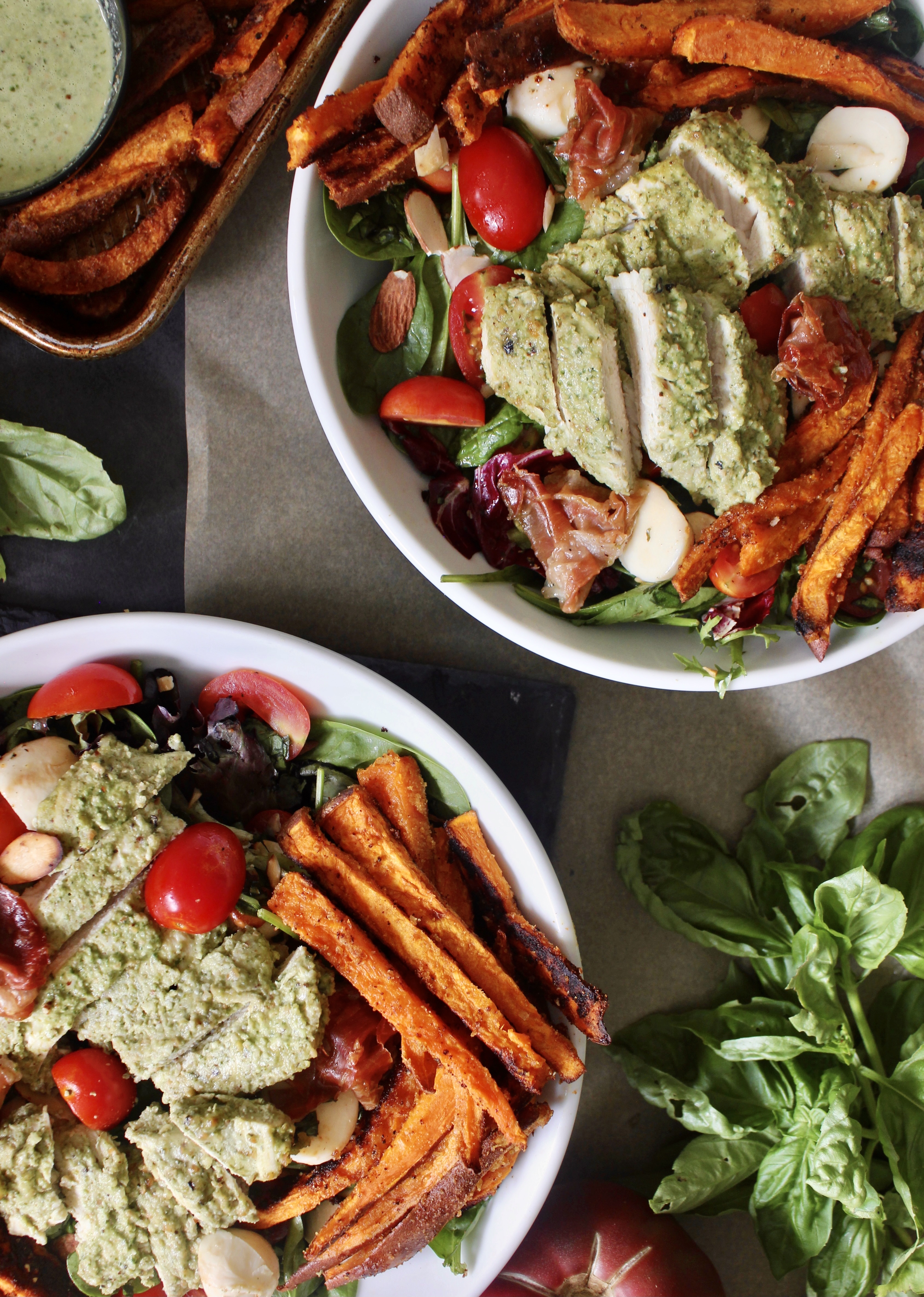 Crispy roasted sweet potato fries and prosciutto baked with juicy pesto chicken and tossed with fresh mozzarella, cherry tomatoes, and simply dressed greens: this Pesto Chicken Sweet Potato Caprese Salad is the ultimate summer salad!