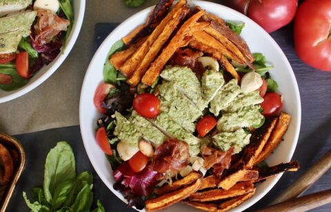 Crispy roasted sweet potato fries and prosciutto baked with juicy pesto chicken and tossed with fresh mozzarella, cherry tomatoes, and simply dressed greens: this Pesto Chicken Sweet Potato Caprese Salad is the ultimate summer salad!