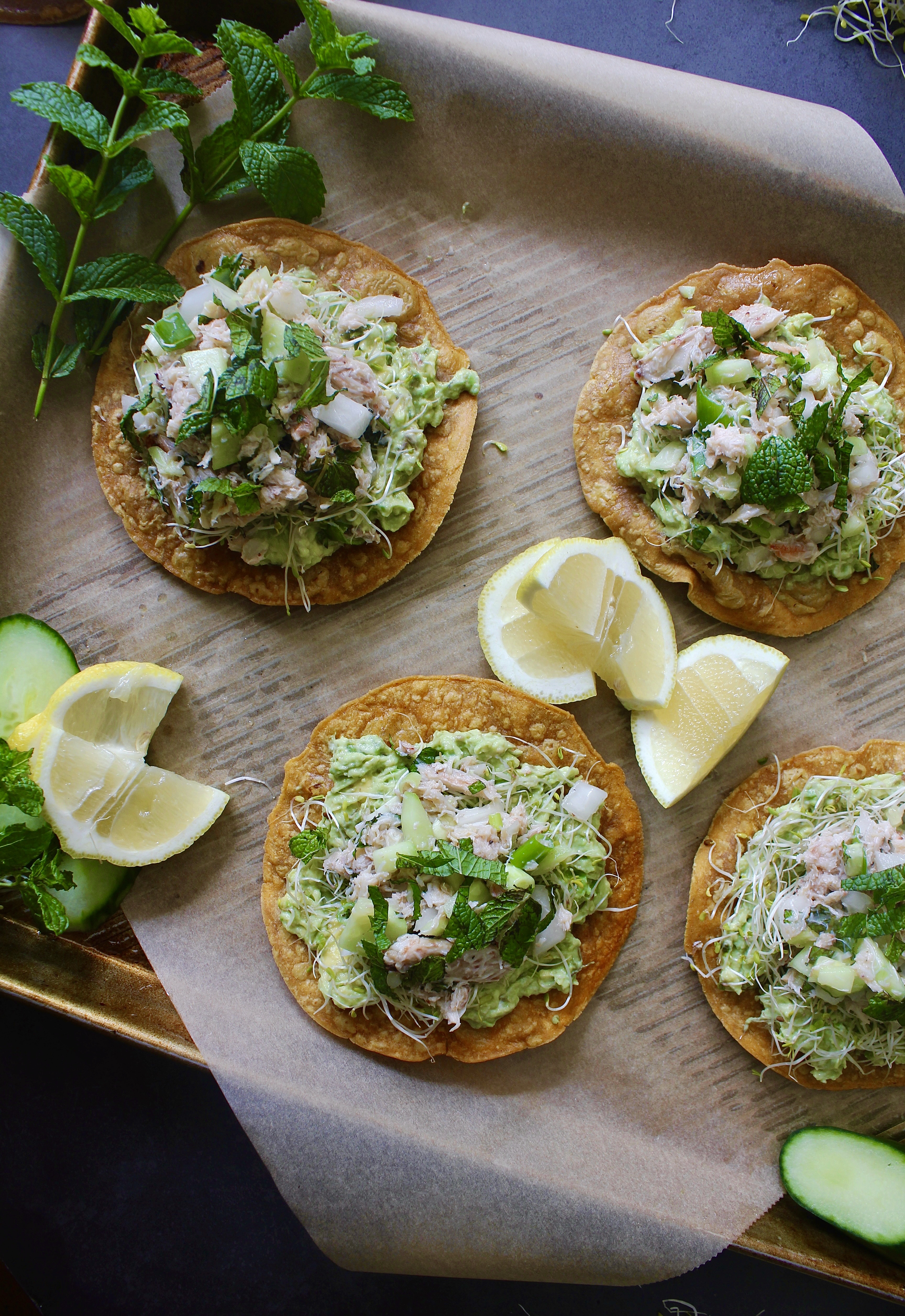 Creamy tangy jumbo lump crab slaw, avocado, and greens layered over a crispy oven baked tostada shell: these Cucumber Avocado Crab Slaw Tostadas are one of my favorite ways to eat crab.