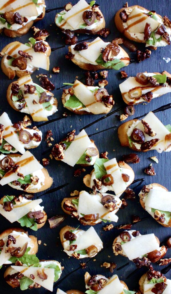 Mini homemade crostini slathered with a creamy honey goat cheese spread and topped with crisp Asian pears and all the good textures: these Whipped Honey Goat Cheese, Pear, and Balsamic Crostini are my favorite party appetizer!