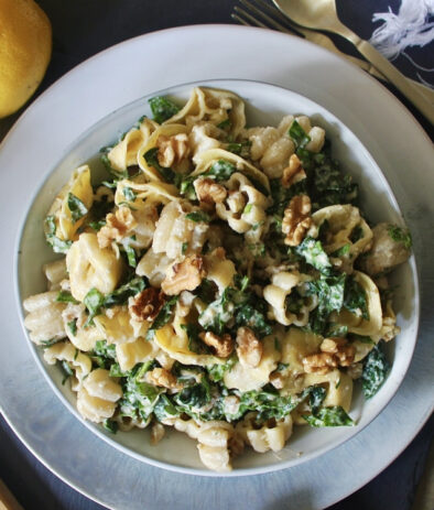 A creamy crunchy walnut parmesan dressing massaged into kale and tossed with chilled cheese tortellini: this Parmesan Kale Tortellini Pasta Salad makes for the best summer side!!