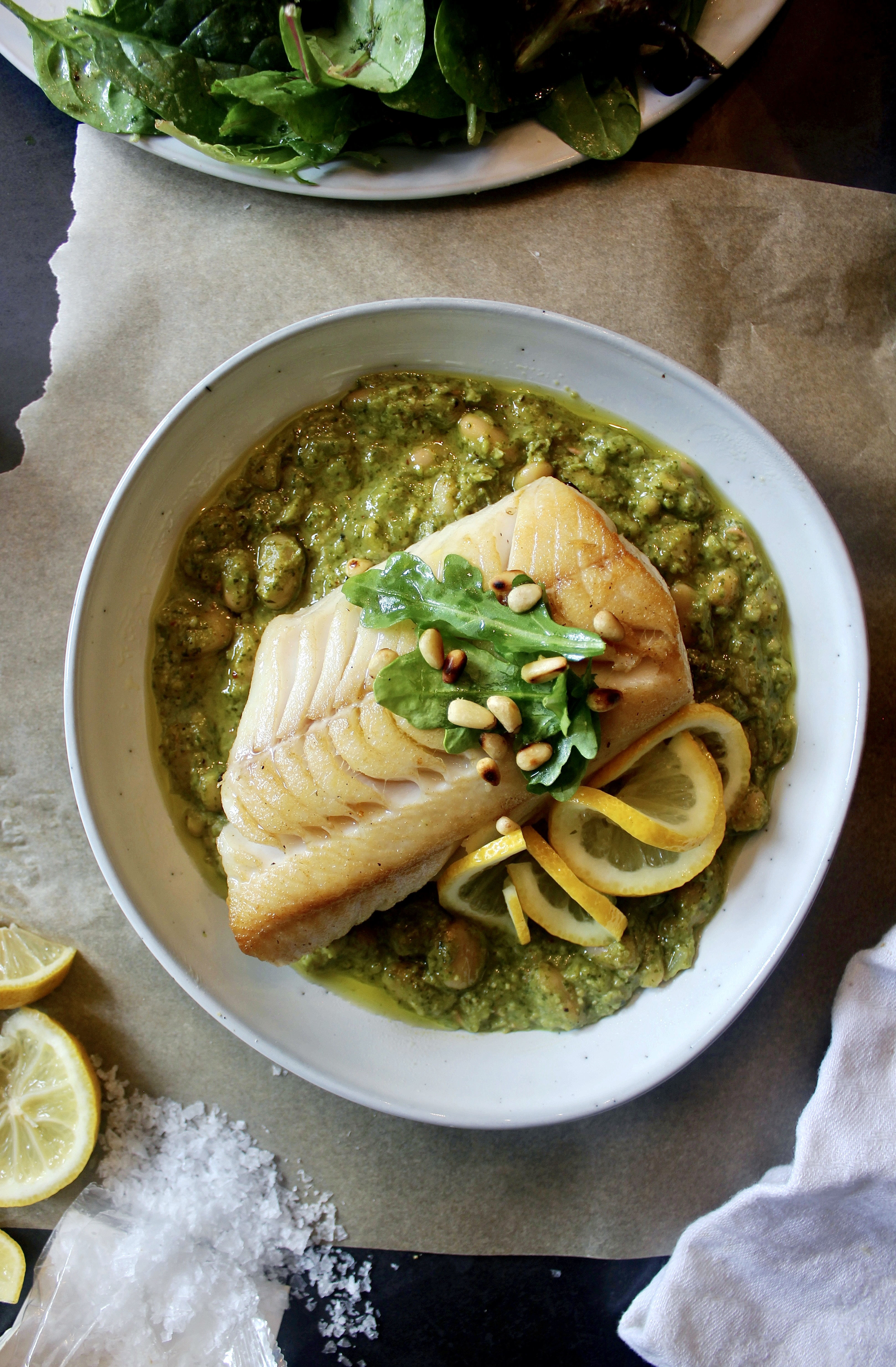Golden seared fish over a creamy beans stirred with a fresh homemade pesto: this  Crispy Fish Over Arugula Pesto White Beans is a mouthful of flavor!!