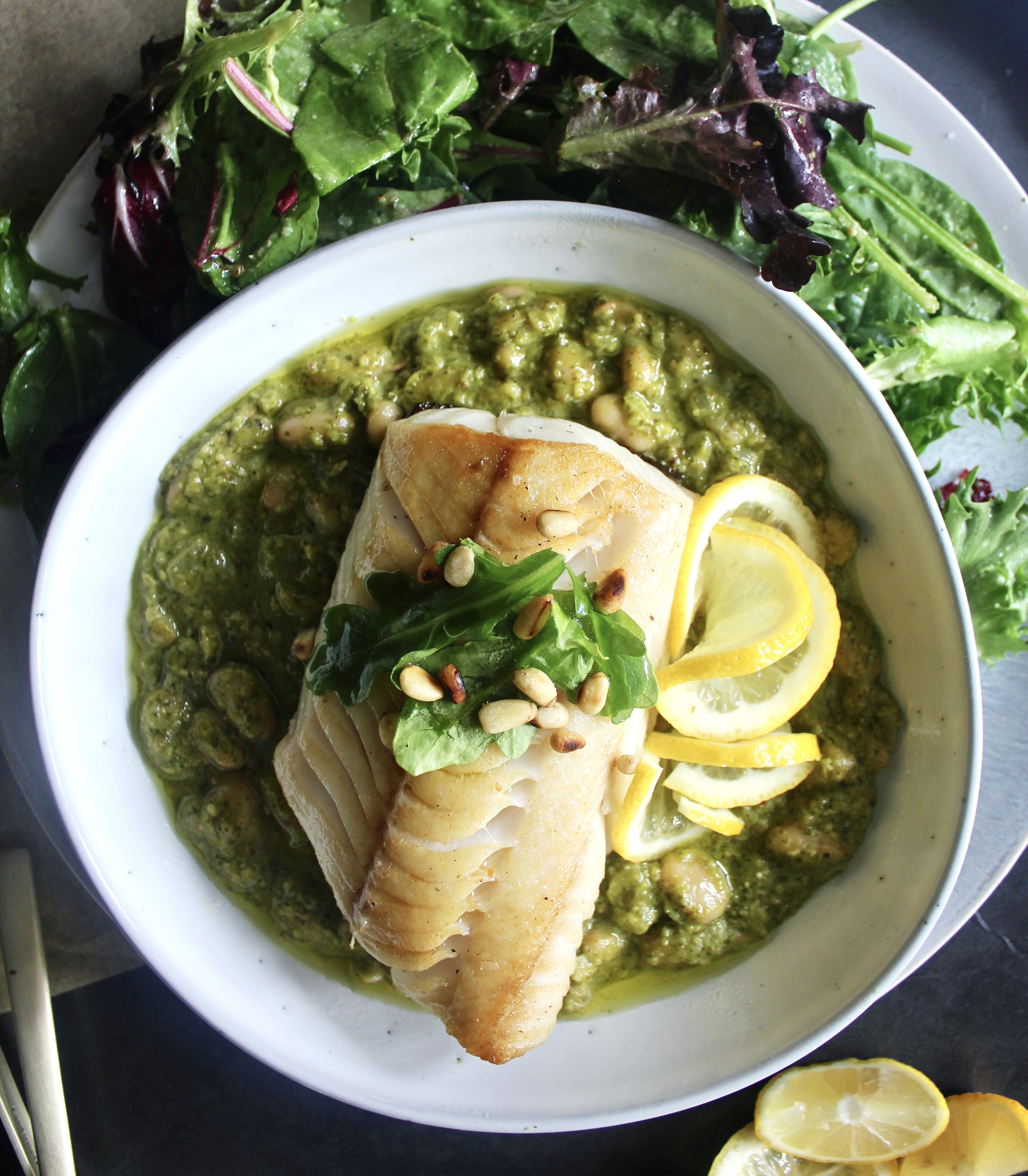 Golden seared fish over a creamy beans stirred with a fresh homemade pesto: this  Crispy Fish Over Arugula Pesto White Beans is a mouthful of flavor!!