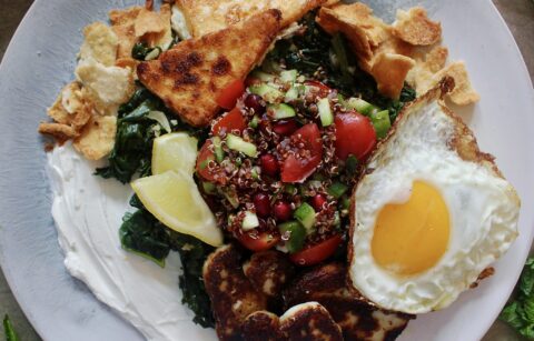 A creamy layer of lemony labneh, white wine garlicky wilted kale, and a few spoonfuls of a pomegranate quinoa salad all finished off with crispy cheese and a fried egg: these Loaded Lebanese Kale, Quinoa Salad, and Fried Egg Plates are seriously next-level amazing.