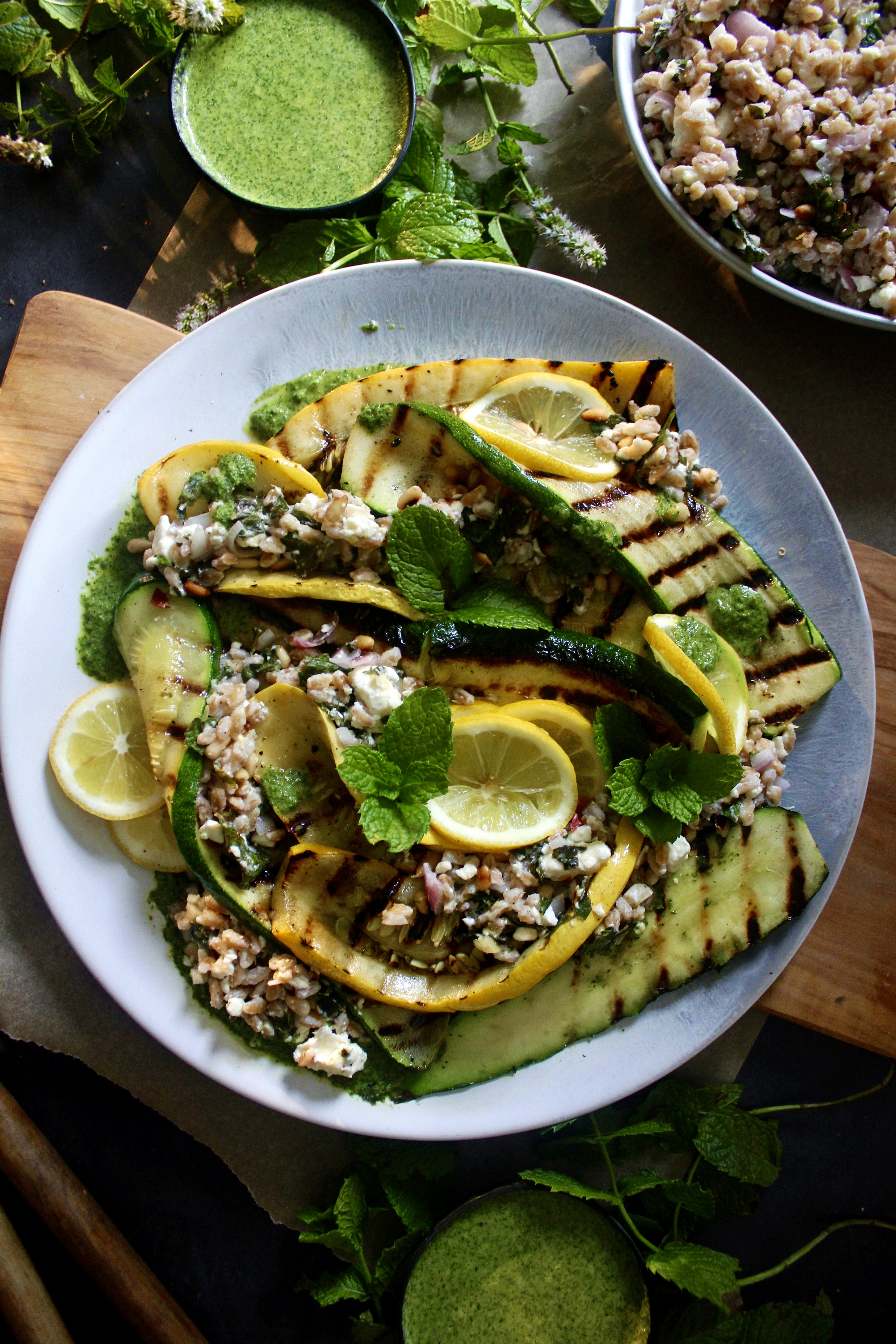 Crispy toasted farro tossed with zesty lemon, fresh mint, and creamy feta topped over charred summer squash and finished with a drizzle of mint vinaigrette: this Grilled Summer Squash Mint and Toasted Farro Salad is truly the summer salad of your dreams.