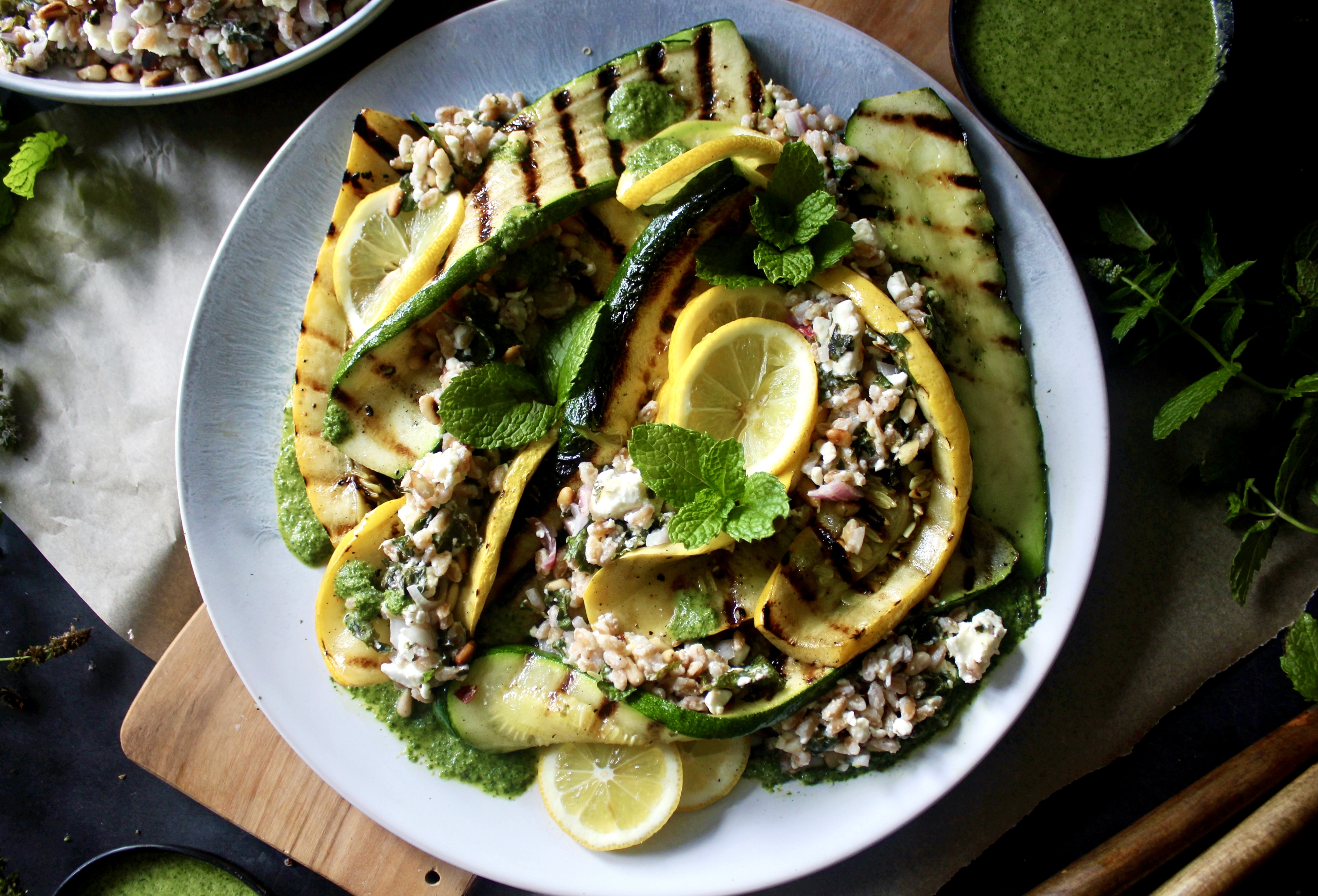 Crispy toasted farro tossed with zesty lemon, fresh mint, and creamy feta topped over charred summer squash and finished with a drizzle of mint vinaigrette: this Grilled Summer Squash Mint and Toasted Farro Salad is truly the summer salad of your dreams.