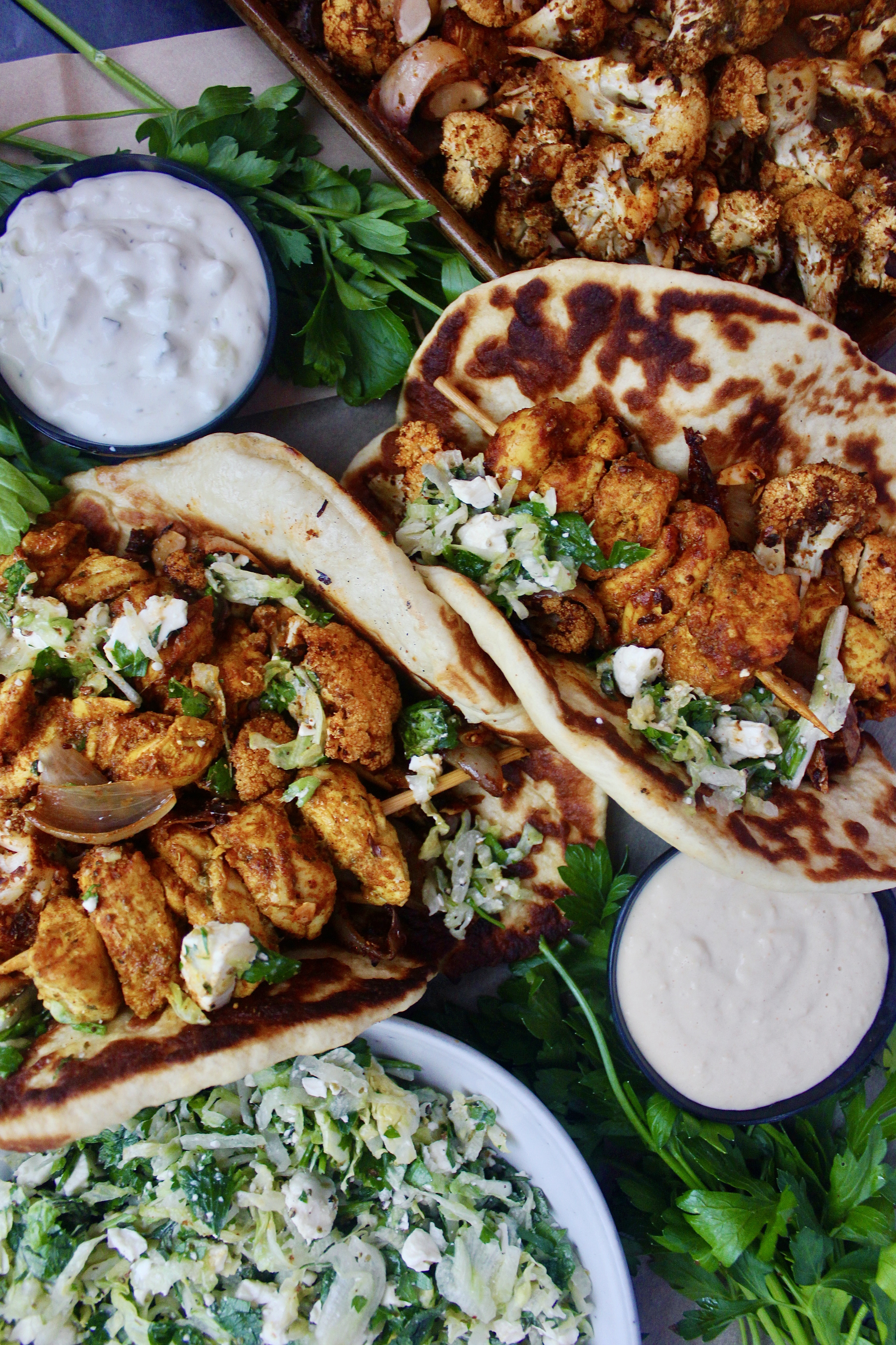 Fluffy, warm homemade naan wrapped around juicy crisp shawarma chicken and cauliflower with your favorite dip and a quick parsley salad: these Greek Chicken and Cauliflower Naan Wraps with Parsley Salad are seriously next level amazing. 