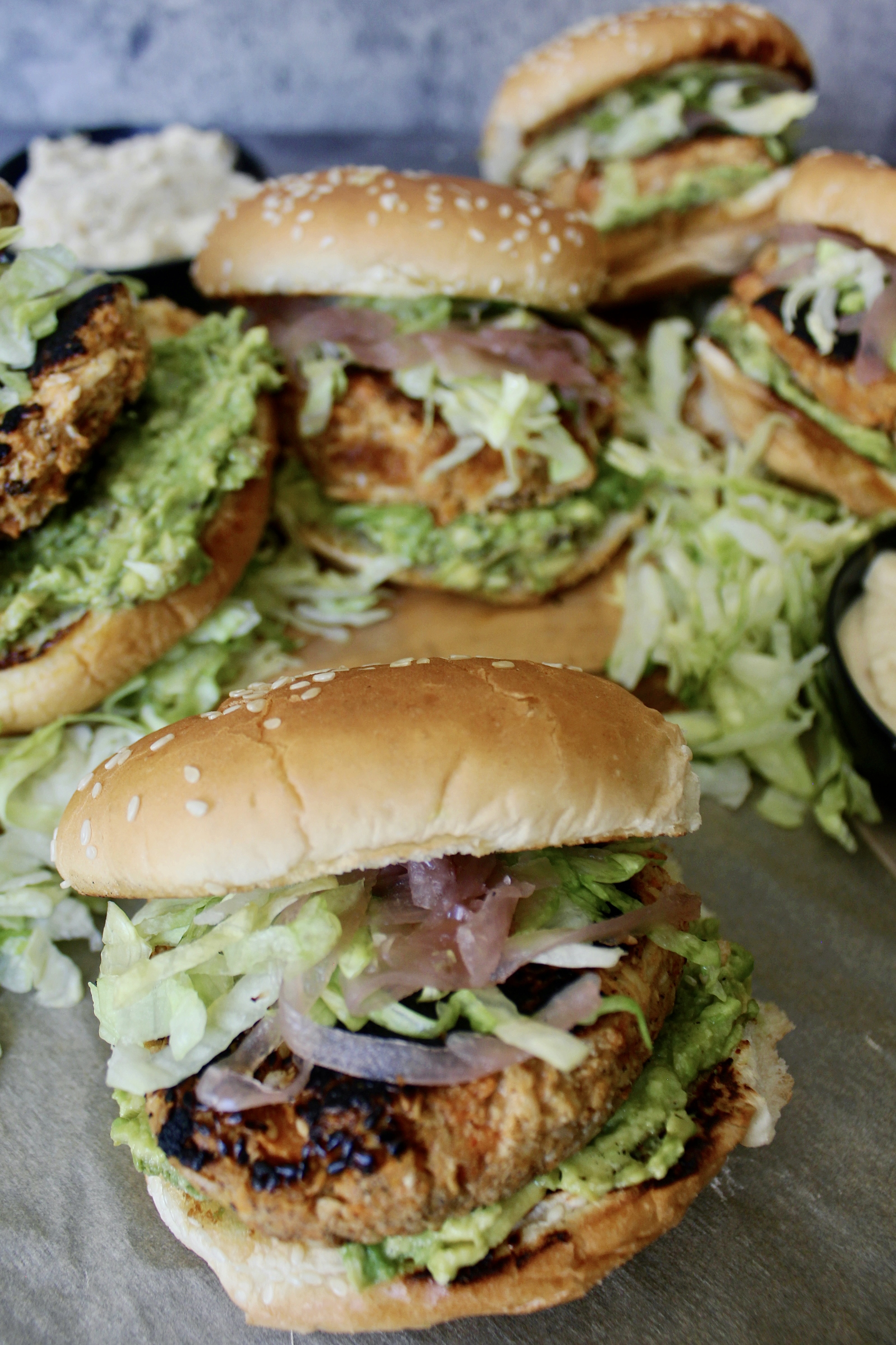 Juicy pulled chicken folded in with warming spices, sweet potato, and tahini topped off with avocado and pickled onions: these Sweet Potato Pulled Chicken Tahini Burgers are an all time fav!!