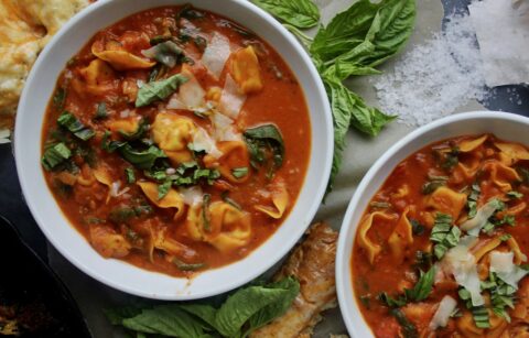 Cheese tortellini tossed into a cozy, hearty bowl of homemade tomato soup with tons of parmesan and fresh spinach: this Lightened Up Creamy Tomato and Tortellini Soup makes for the best warming dinner.
