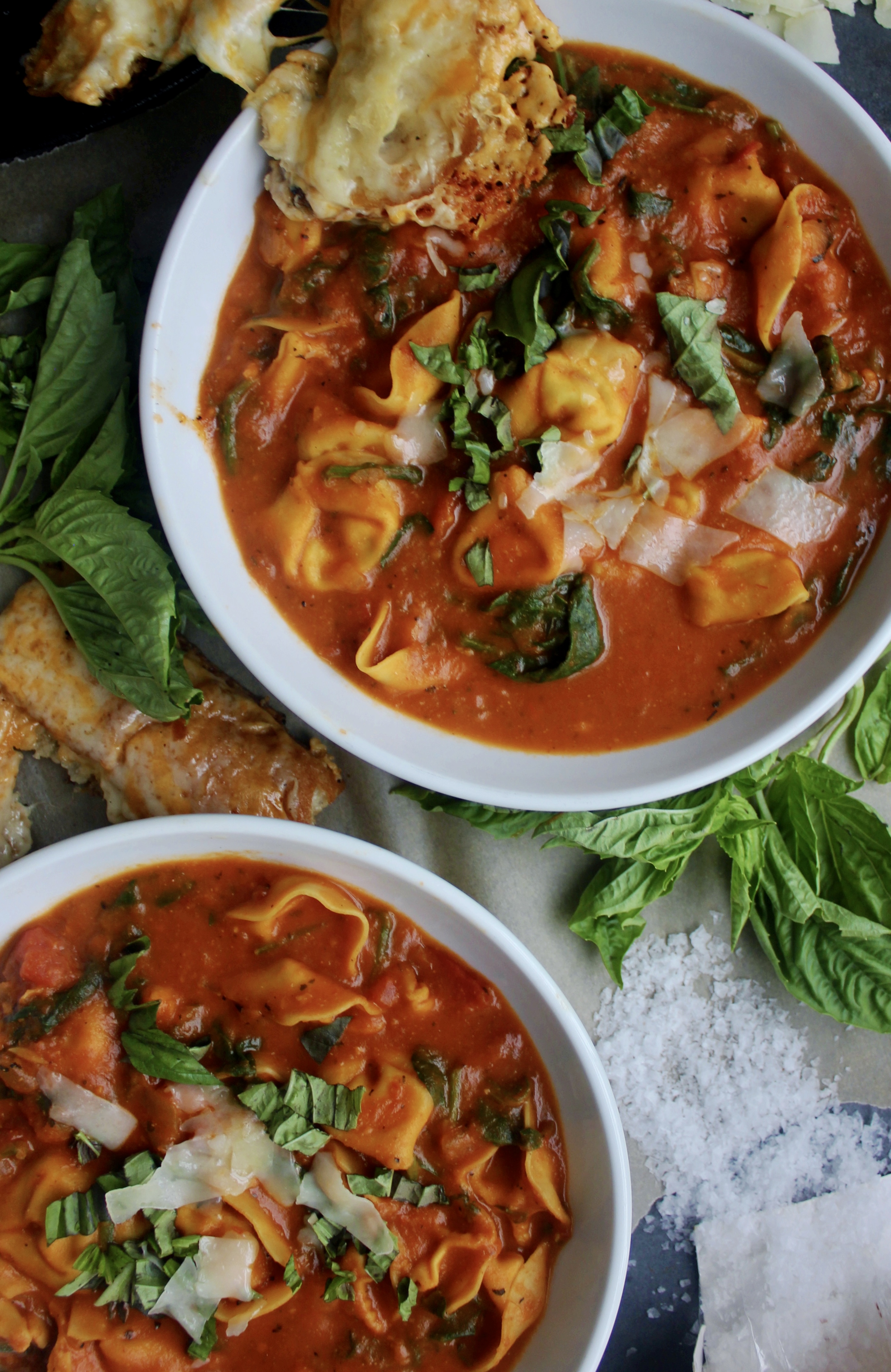 Cheese tortellini tossed into a cozy, hearty bowl of homemade tomato soup with tons of parmesan and fresh spinach: this Lightened Up Creamy Tomato and Tortellini Soup makes for the best warming dinner.