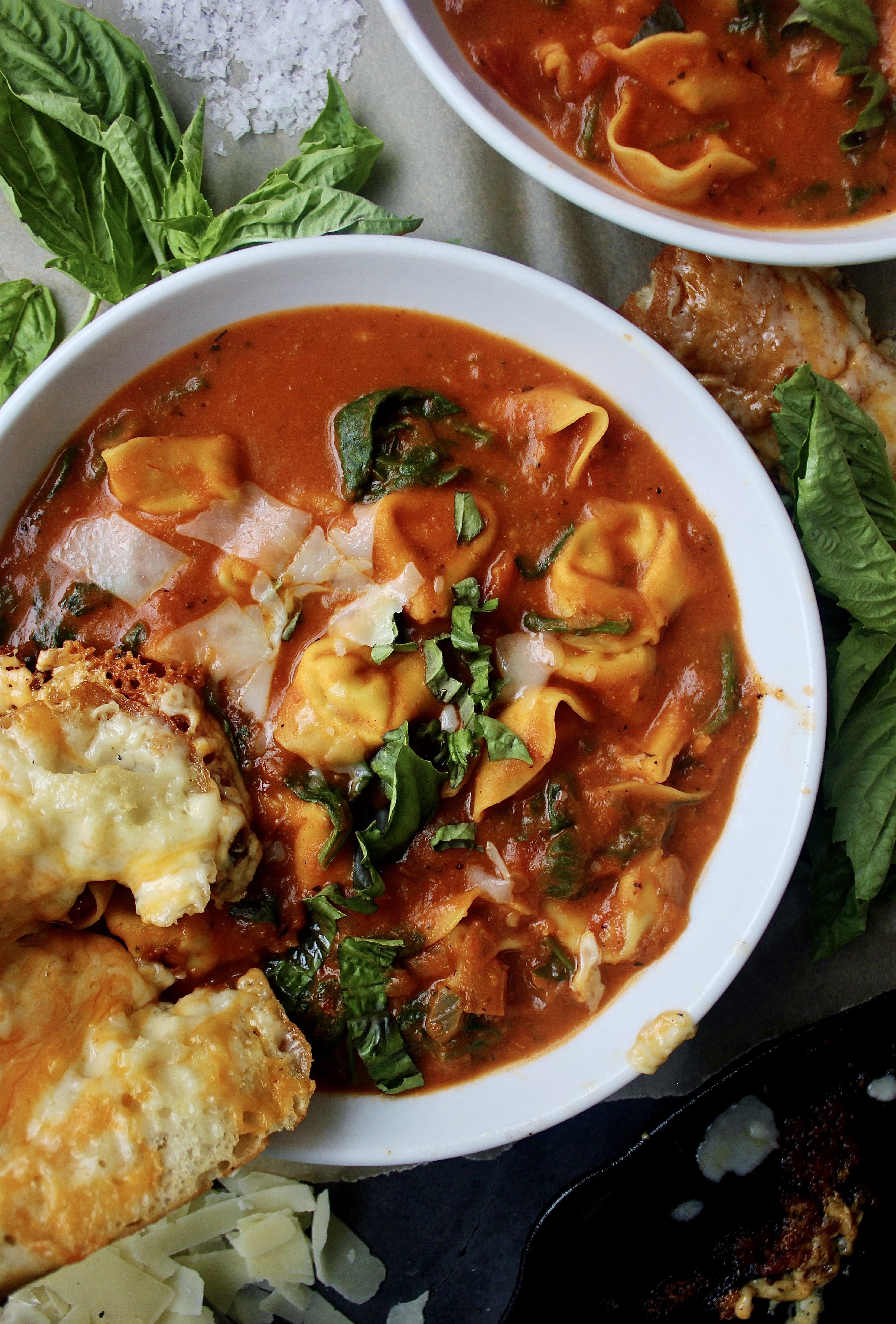 Cheese tortellini tossed into a cozy, hearty bowl of homemade tomato soup with tons of parmesan and fresh spinach: this Lightened Up Creamy Tomato and Tortellini Soup makes for the best warming dinner.