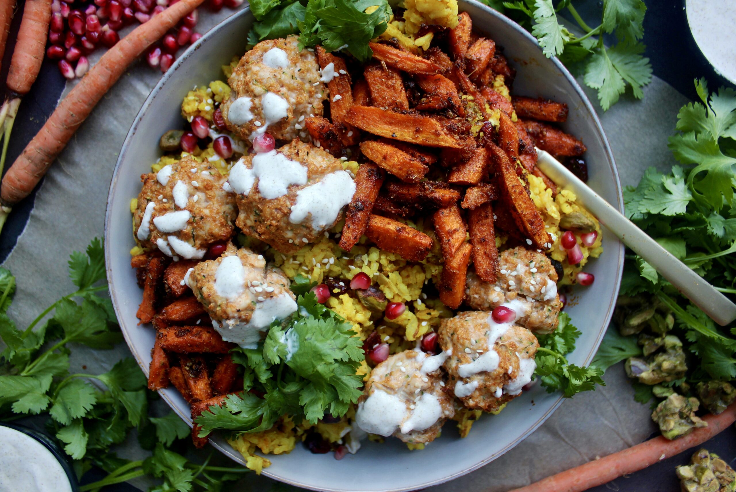 Spiced turmeric saffron rice with super simple Moroccan flavored meatballs topped with a creamy lemon yogurt sauce and tangy pomegranate seeds: these Super Simple Golden Rice and Moroccan Meatball Bowls are the best weeknight dinner!