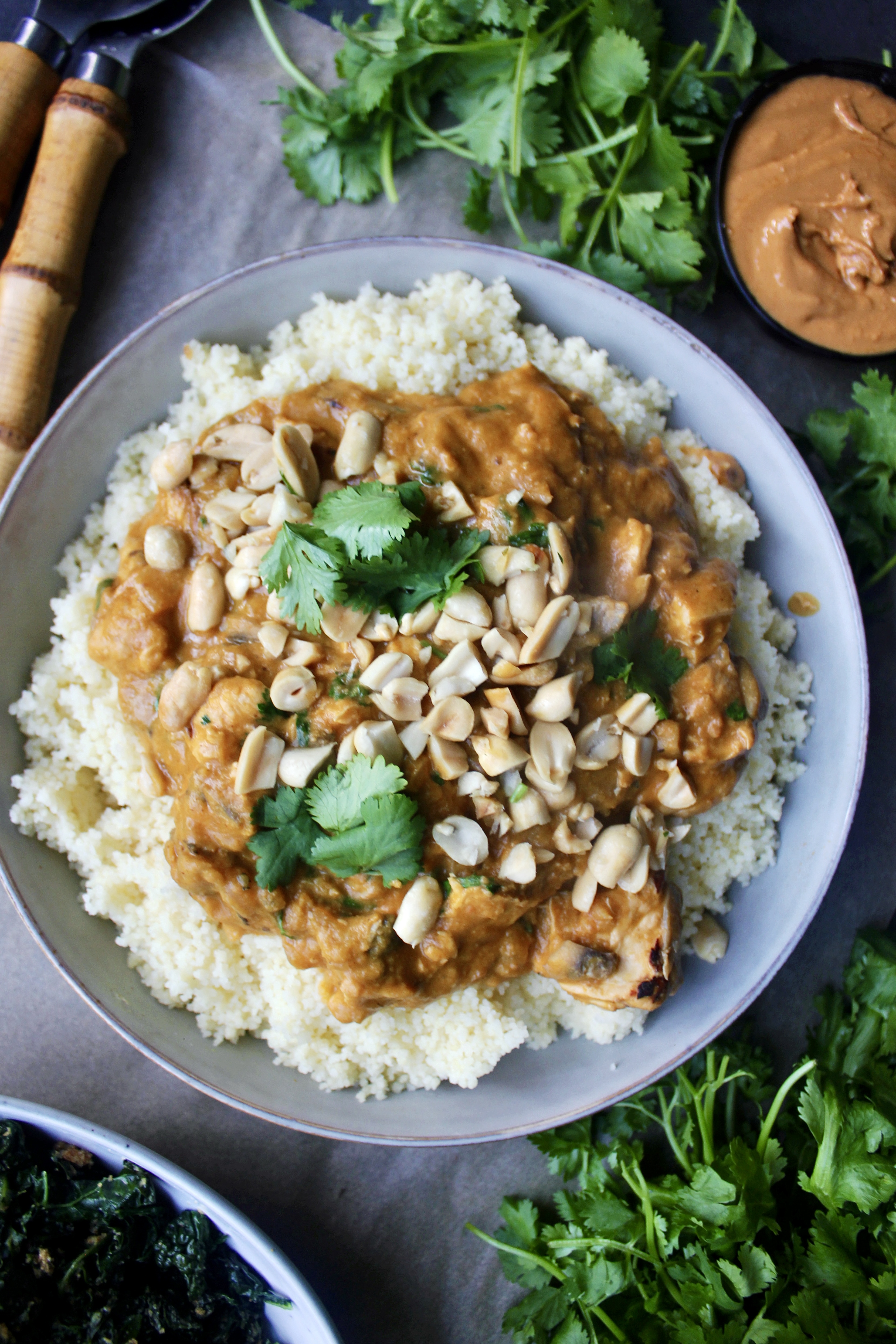 A lighter take on a creamy spiced peanut butter sauce sauteed up with gingery garlicky chicken and served up with wilted kale over your favorite grain: this Healthy African Peanut  Chicken is seriously the best comfort food!