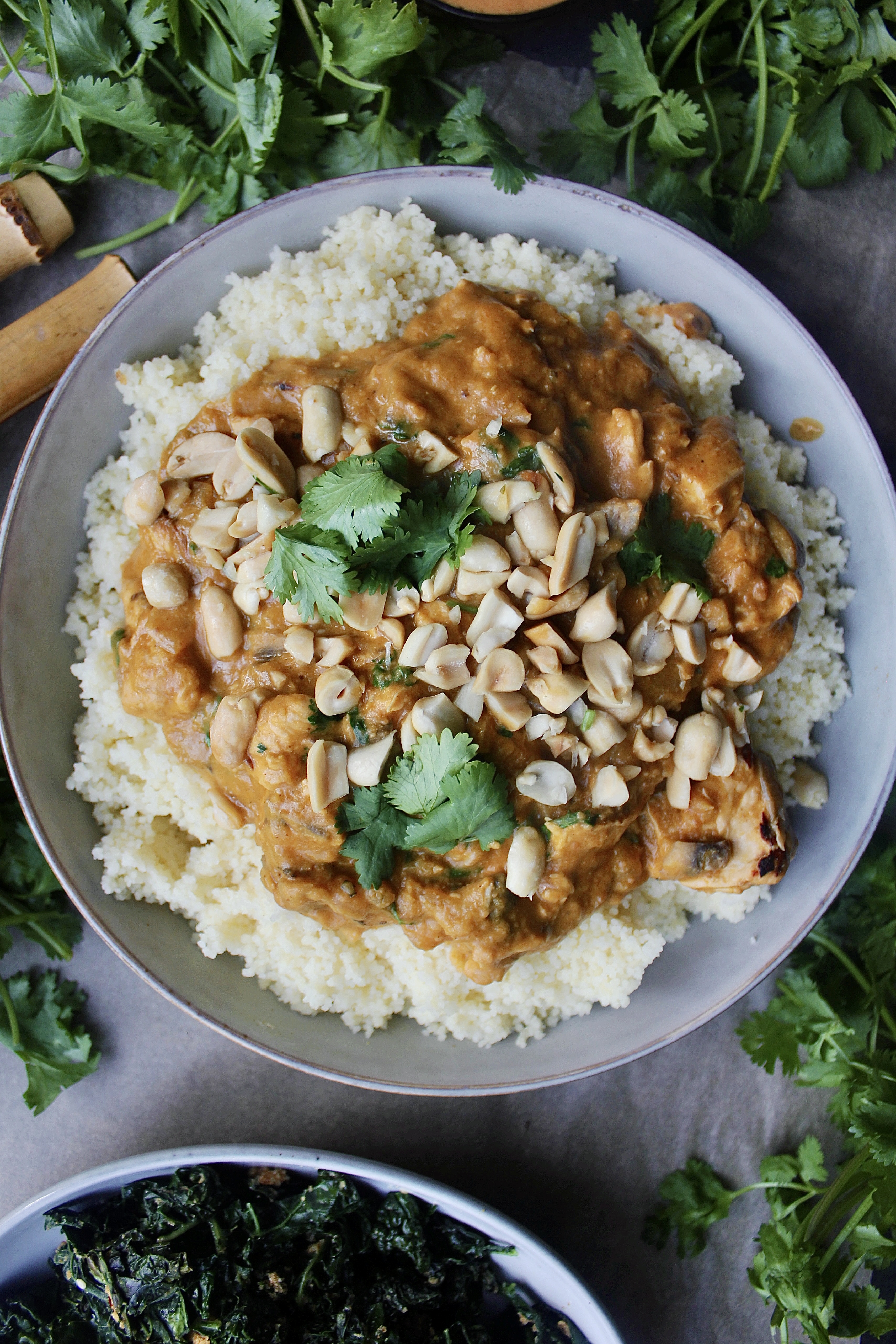 A lighter take on a creamy spiced peanut butter sauce sauteed up with gingery garlicky chicken and served up with wilted kale over your favorite grain: this Healthy African Peanut  Chicken is seriously the best comfort food!