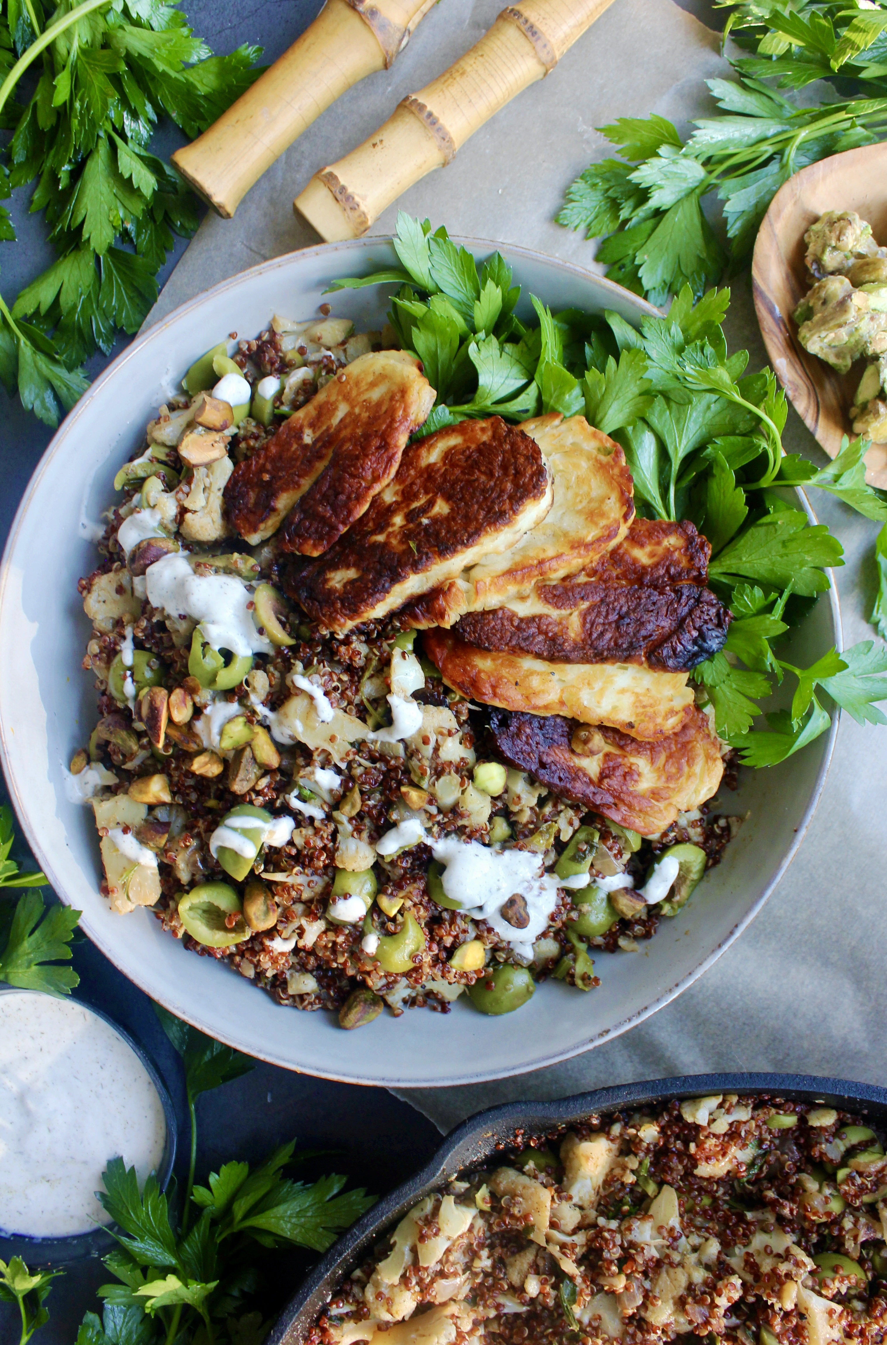 Caramelized garlic onion and cauliflower toss up with an olive and herbed quinoa finished off with some pan fried halloumi cheese and a greek yogurt drizzle: these Charred Halloumi Mediterranean Red Quinoa Bowls are the most epic meatless dinner!