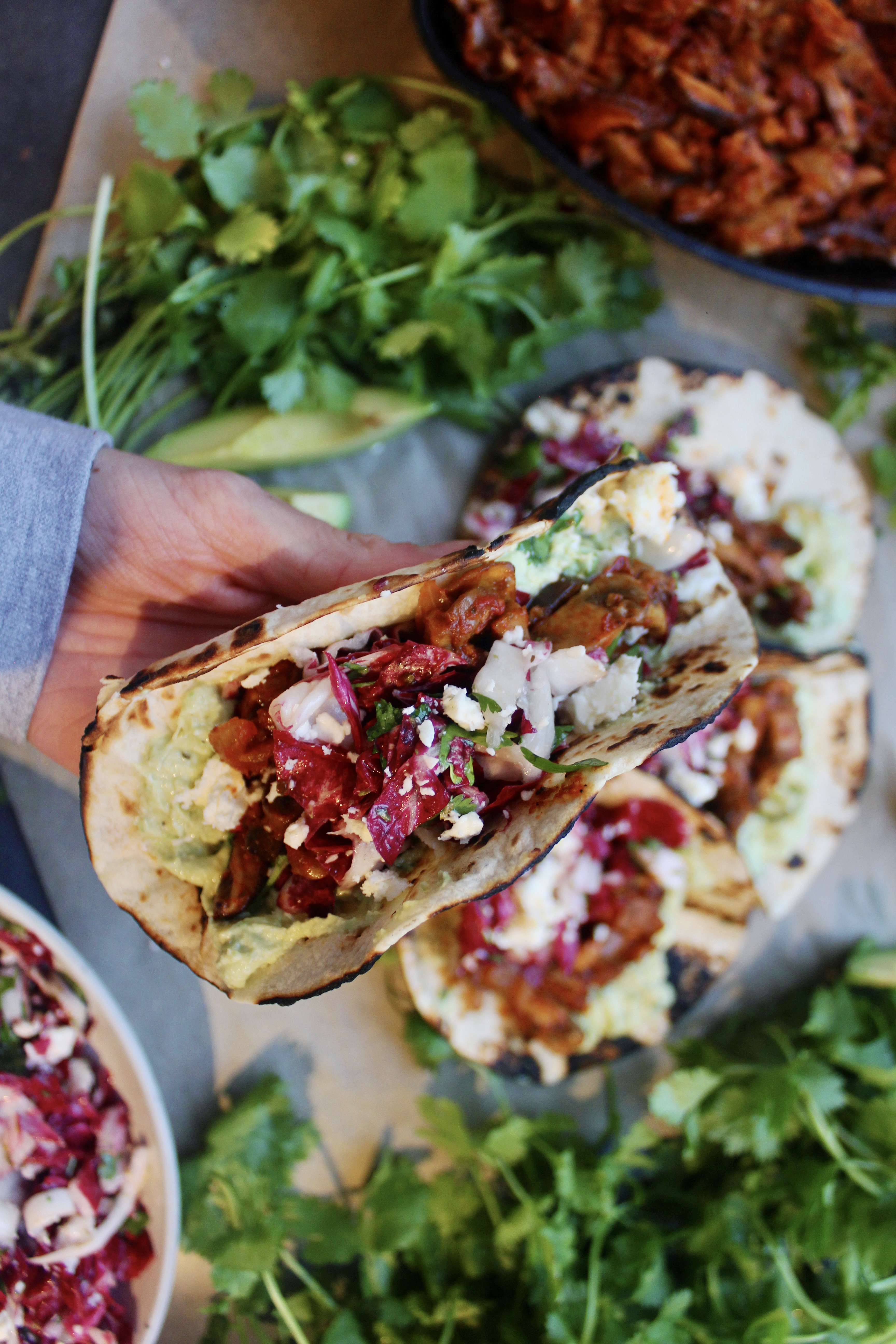 Caramelized, Mexican spiced mushrooms layered over a creamy mashed avocado crema and finished with a tart cotija cilantro slaw: these Caramelized Shiitake Tacos with Cotija Cilantro Slaw are the ultimate vegetarian taco!