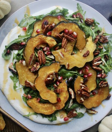 A thick, creamy layer of whipped mascarpone topped with lightly dressed arugula, perfectly roasted acorn squash, all the crispy crunchy textures, and a drizzle of spicy honey: this Maple Roasted Acorn Squash with Mascarpone, Pomegranate, and Hot Honey is the ultimate fall party pleaser!