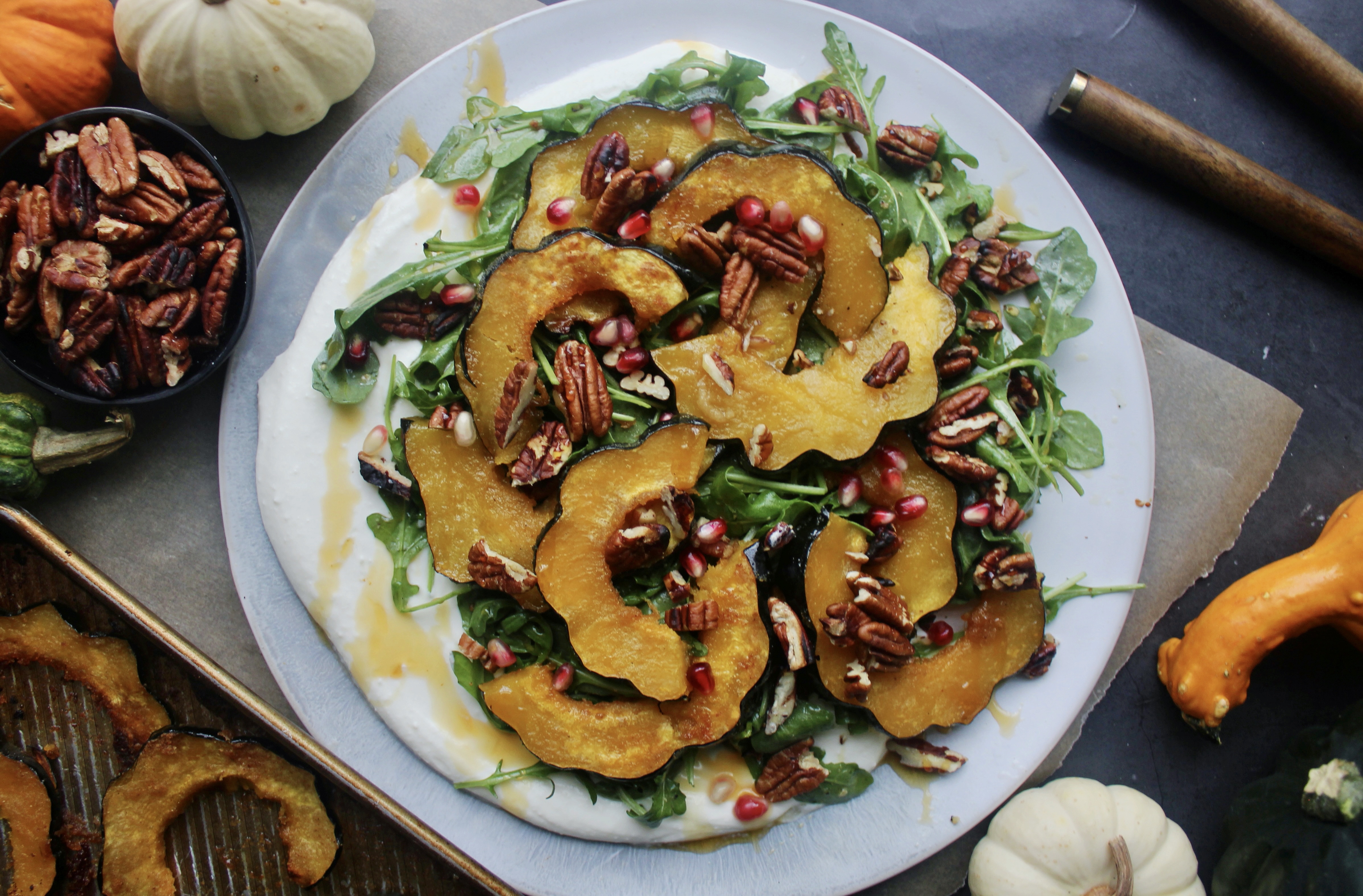 A thick, creamy layer of whipped mascarpone topped with lightly dressed arugula, perfectly roasted acorn squash, all the crispy crunchy textures, and a drizzle of spicy honey: this Maple Roasted Acorn Squash with Mascarpone, Pomegranate, and Hot Honey is the ultimate fall party pleaser!
