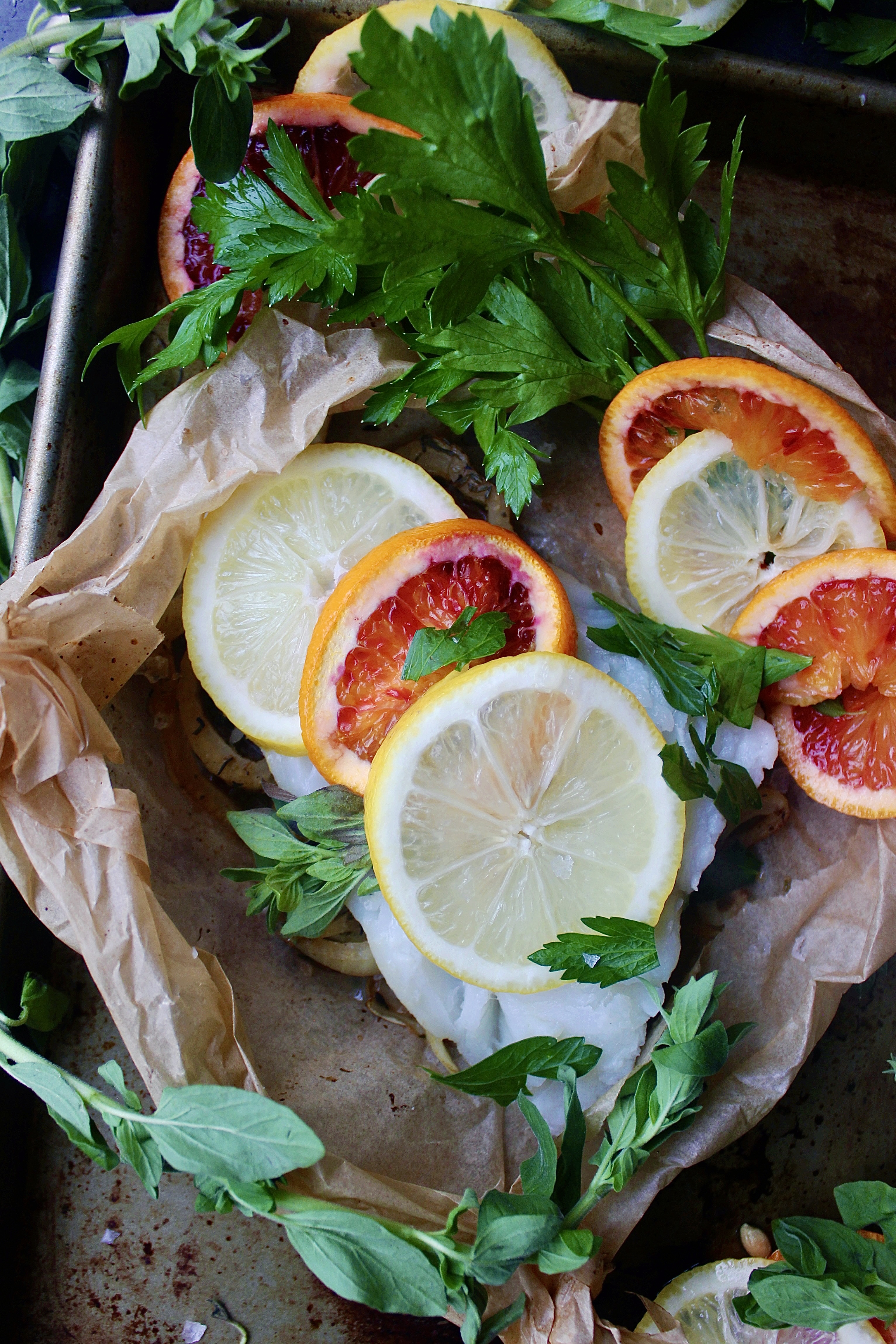 White wine caramelized fennel and shallots under a flaky white fish with layers of blood orange and lemon all tucked into a folded parchment square: this Citrus Fennel Baked Fish en Papillote is truly a package of flavor!