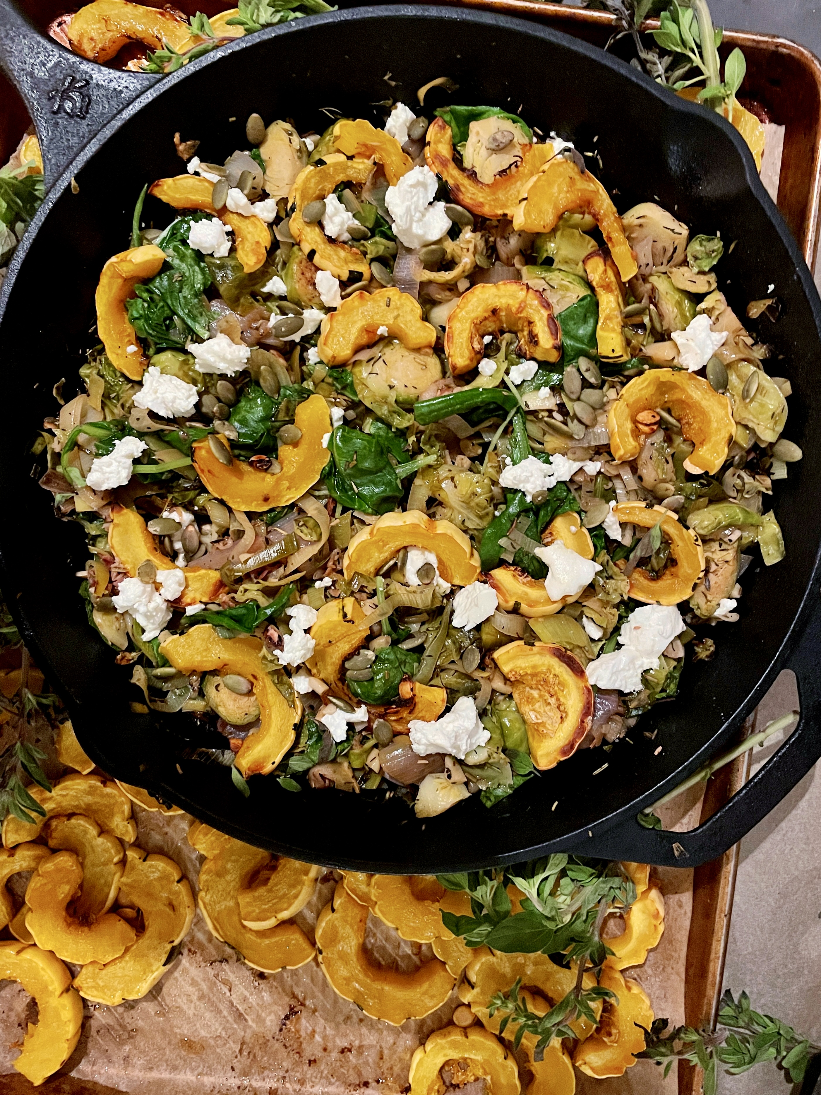 Perfectly charred roasted delicata squash with white wine apple cider wilted brussels sprouts and leeks all tossed up with some tuscan kale, creamy goat cheese, and crunchy pumpkin seeds: this Herbed Brussels, Leeks, and Roasted Delicata Squash Hash is my favorite way to use up all those fall veggies!!