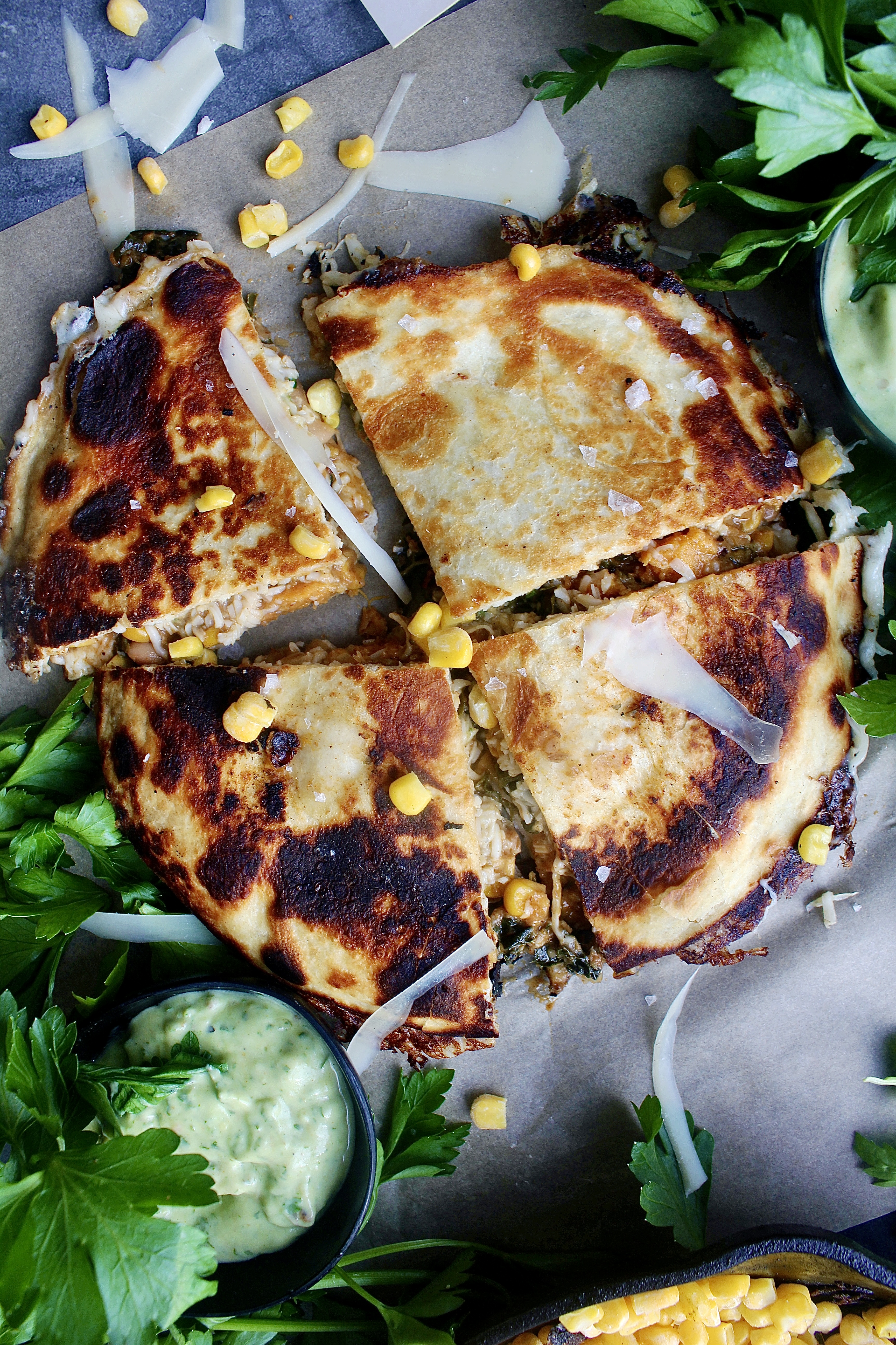 Perfectly seasoned, caramelized sweet potatoes cooked down with corn, white beans, and kale stuffed into a cheesy, toasty tortilla and dipped into a creamy avocado crema: these Sweet Potato White Bean Chili Quesadillas are my favorite easy dinner.