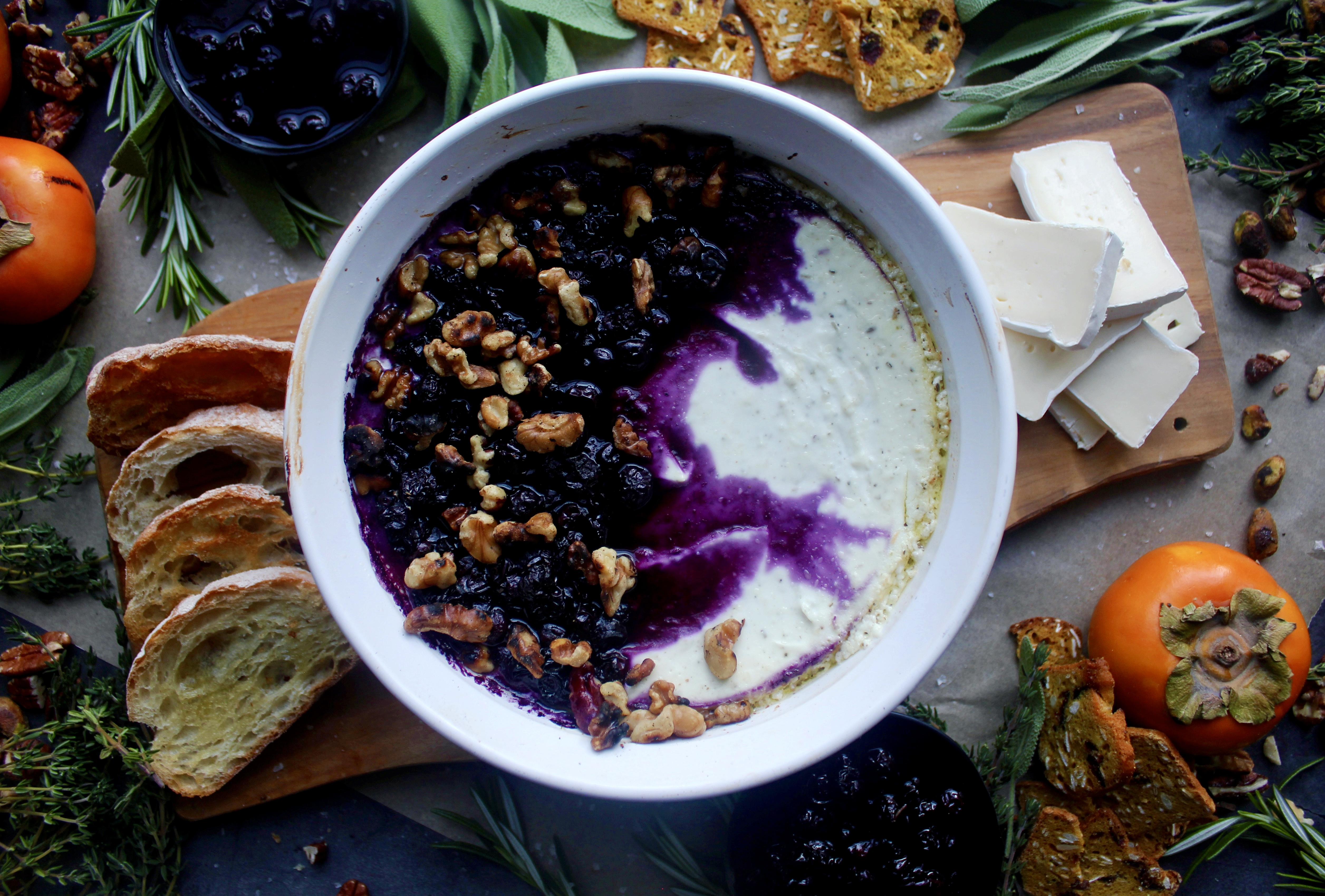 A creamy, tangy whipped three cheese base baked with jammy blueberries all topped off with toasty walnuts and a slice of crusty bread: this Baked Blueberry Walnut Goat Cheese Dip is the ultimate party appetizer!