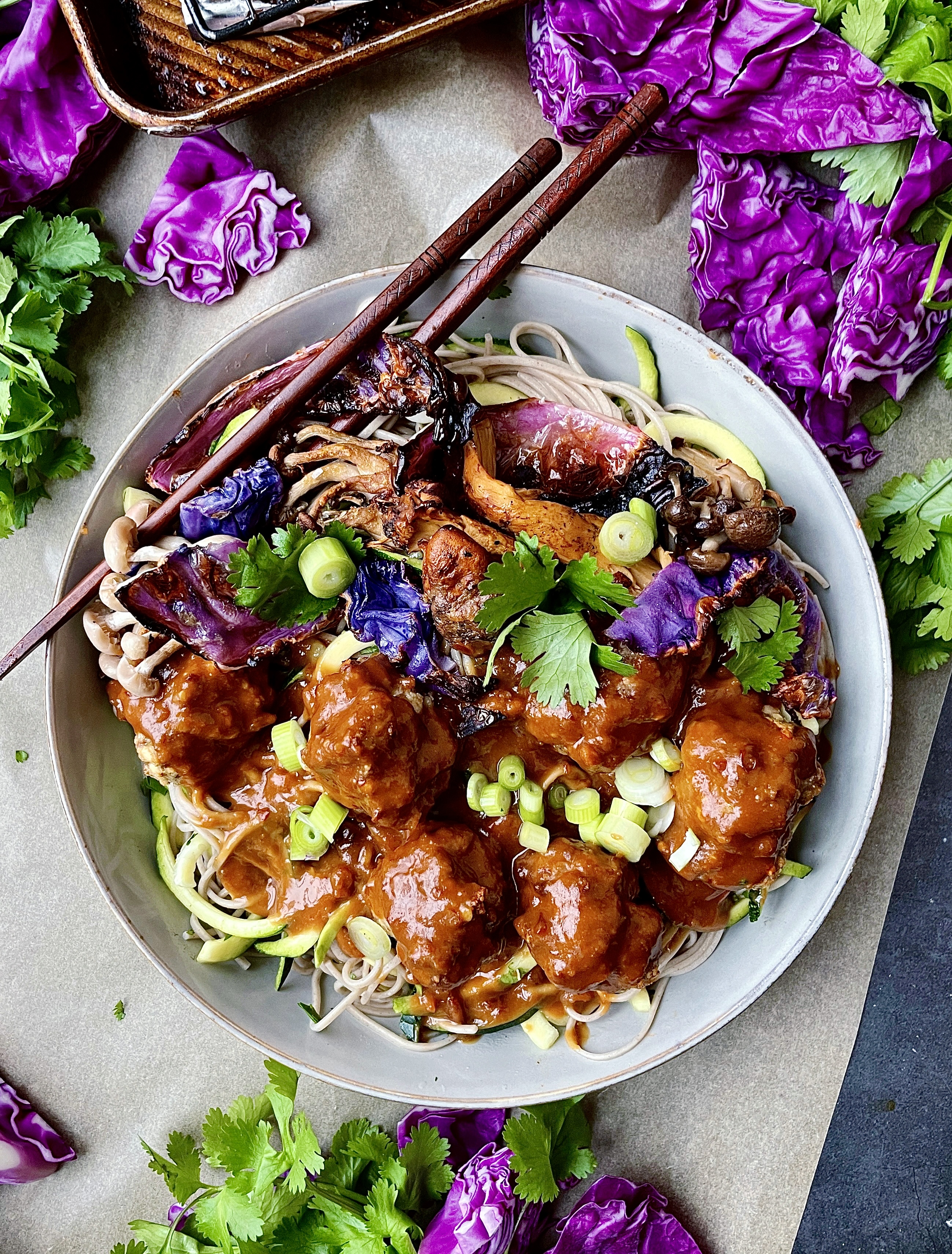 An extra creamy, warm peanut sauce spooned over the easiest baked meatball soba noodle bowl all topped off with crispy cabbage and mushrooms: these Thai Peanut Meatball Noodle Bowls with Crispy Cabbage are a burst of flavor!