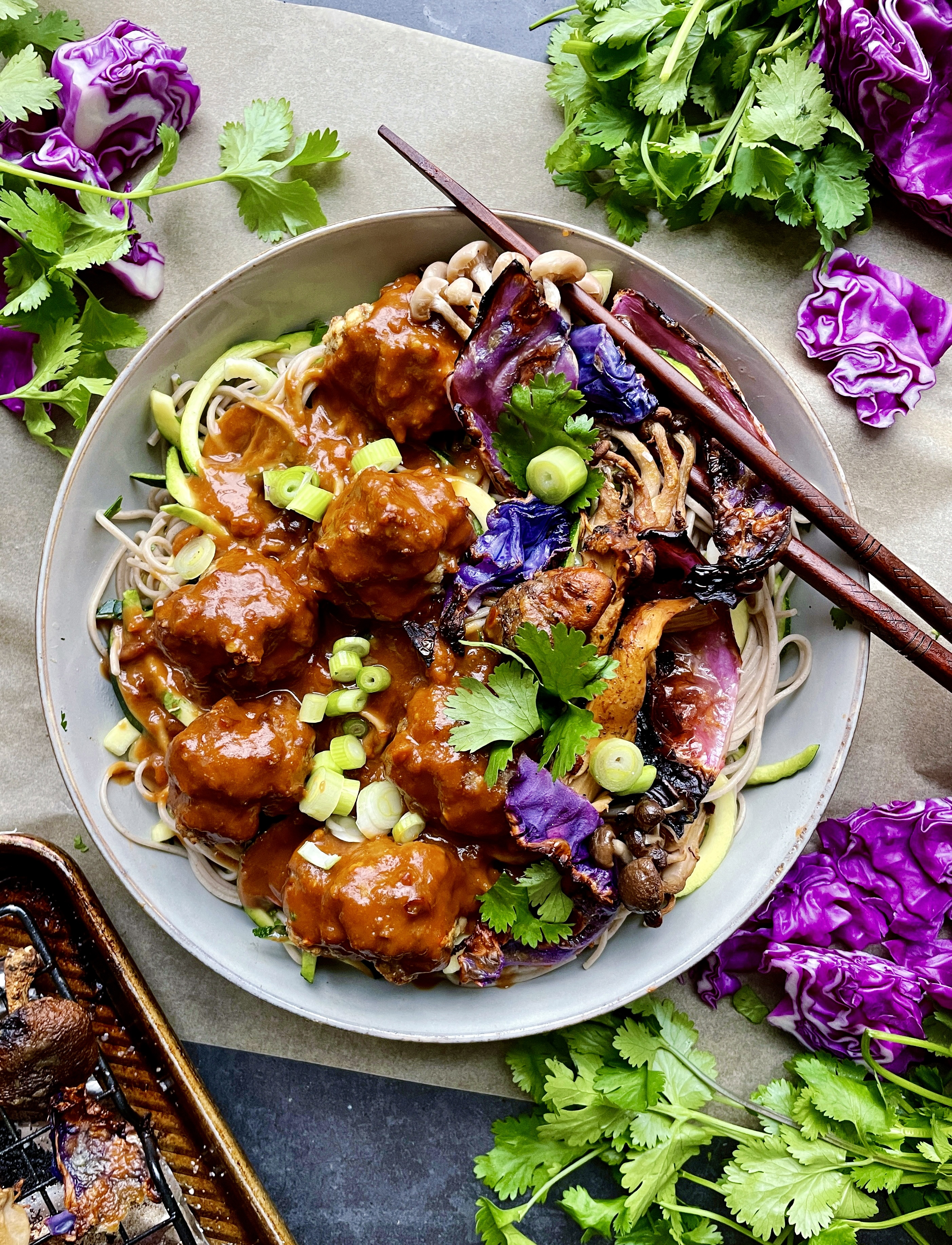 An extra creamy, warm peanut sauce spooned over the easiest baked meatball soba noodle bowl all topped off with crispy cabbage and mushrooms: these Thai Peanut Meatball Noodle Bowls with Crispy Cabbage are a burst of flavor!