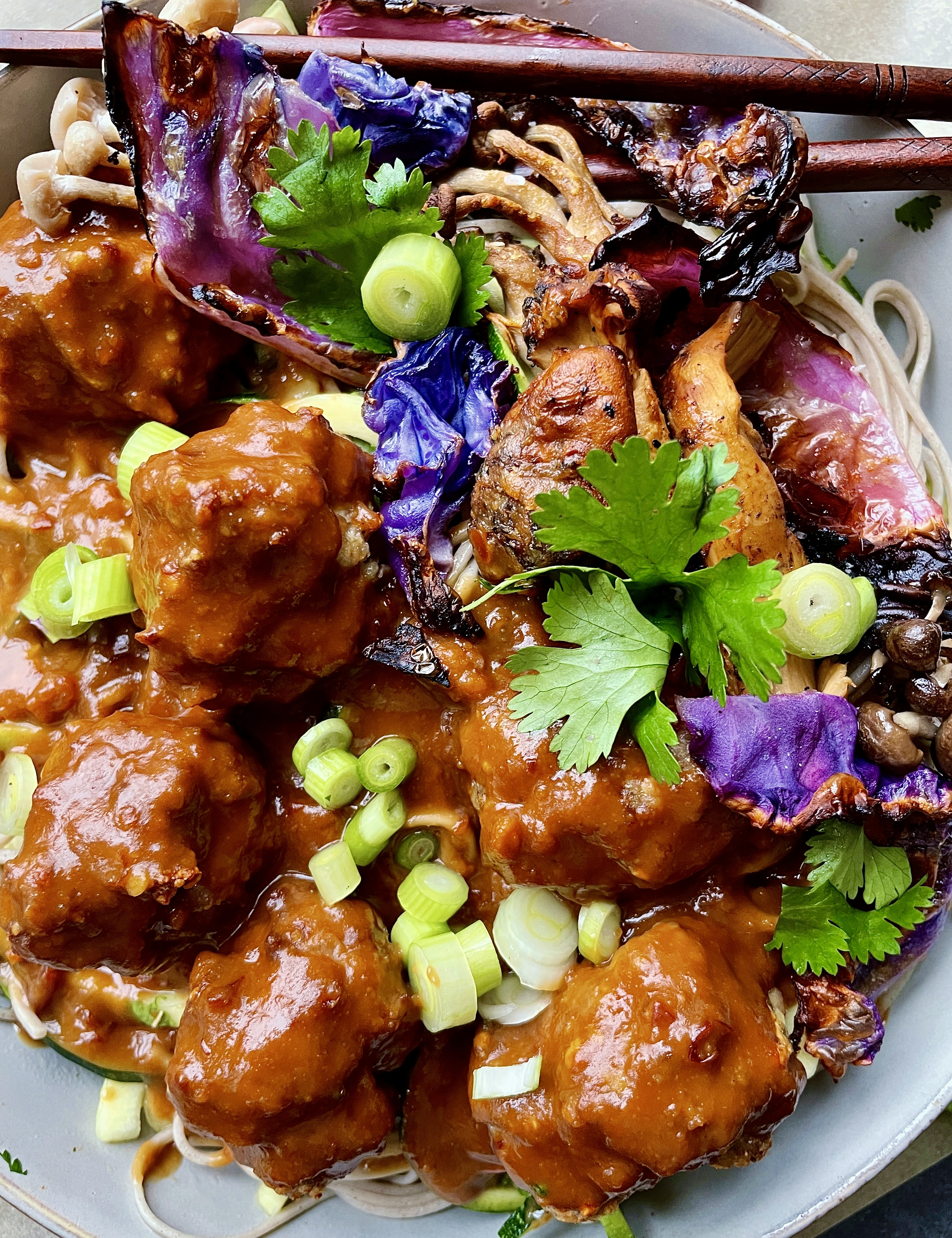 An extra creamy, warm peanut sauce spooned over the easiest baked meatball soba noodle bowl all topped off with crispy cabbage and mushrooms: these Thai Peanut Meatball Noodle Bowls with Crispy Cabbage are a burst of flavor!