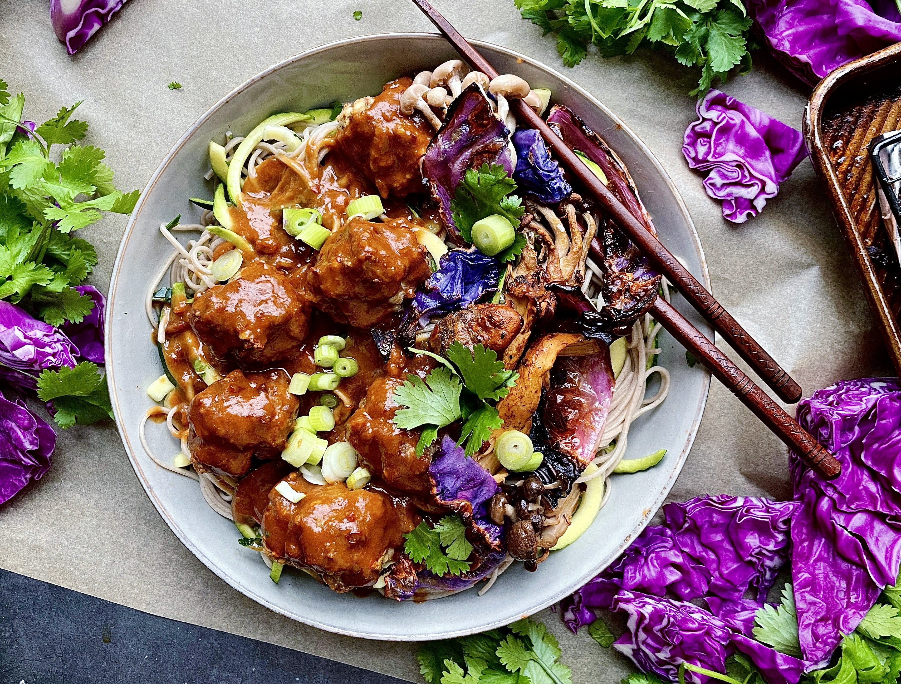 An extra creamy, warm peanut sauce spooned over the easiest baked meatball soba noodle bowl all topped off with crispy cabbage and mushrooms: these Thai Peanut Meatball Noodle Bowls with Crispy Cabbage are a burst of flavor!