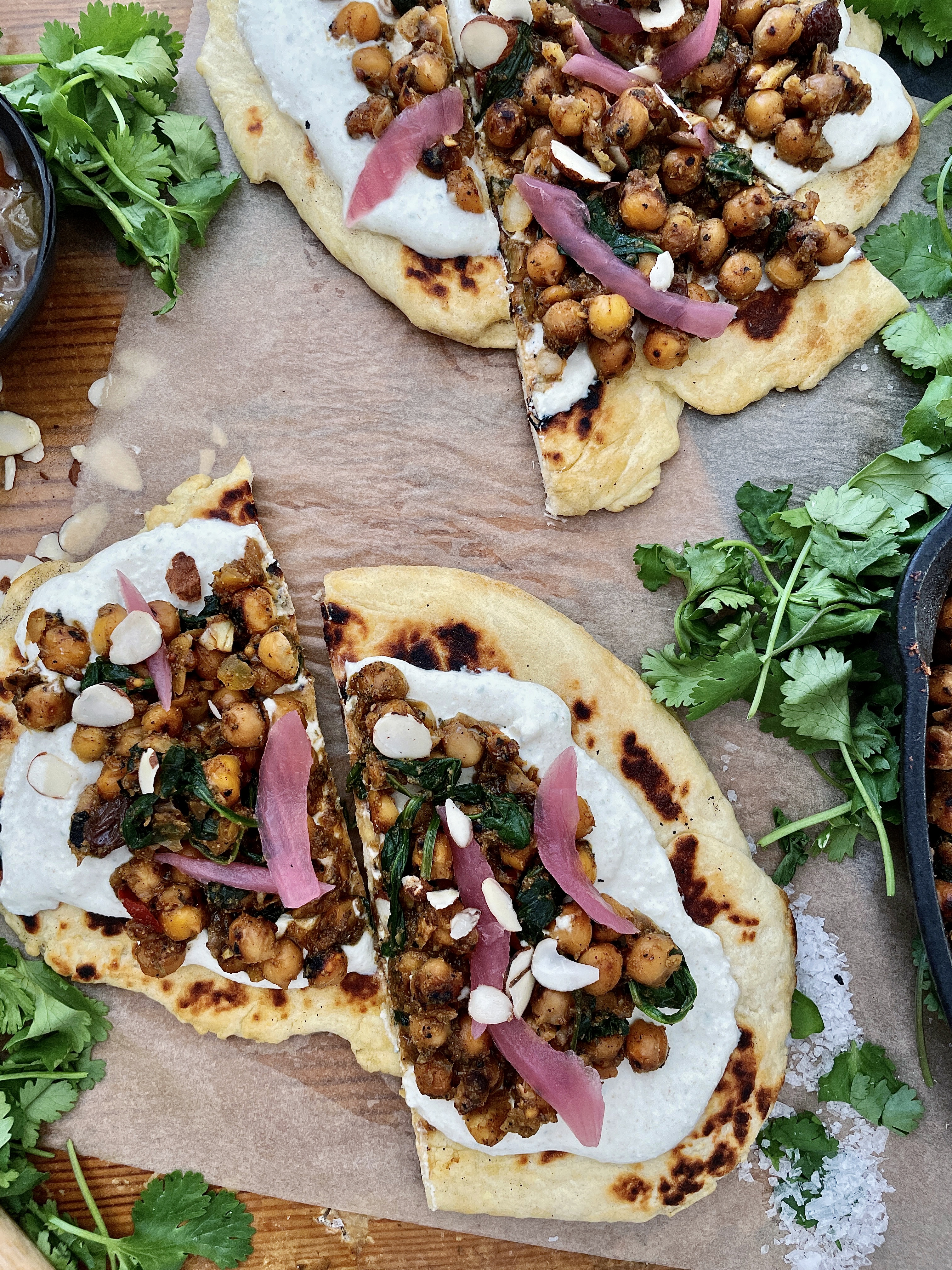  Crispy, crunchy chickpeas toasted in mango chutney and all the good Indian spices wilted down with some garlicky spinach and served over a layer of a salty fresh yogurt sauce and warm naan: these Indian Chickpea Naan Flatbreads with Cucumber Feta Crema are truly a bite of heaven.  