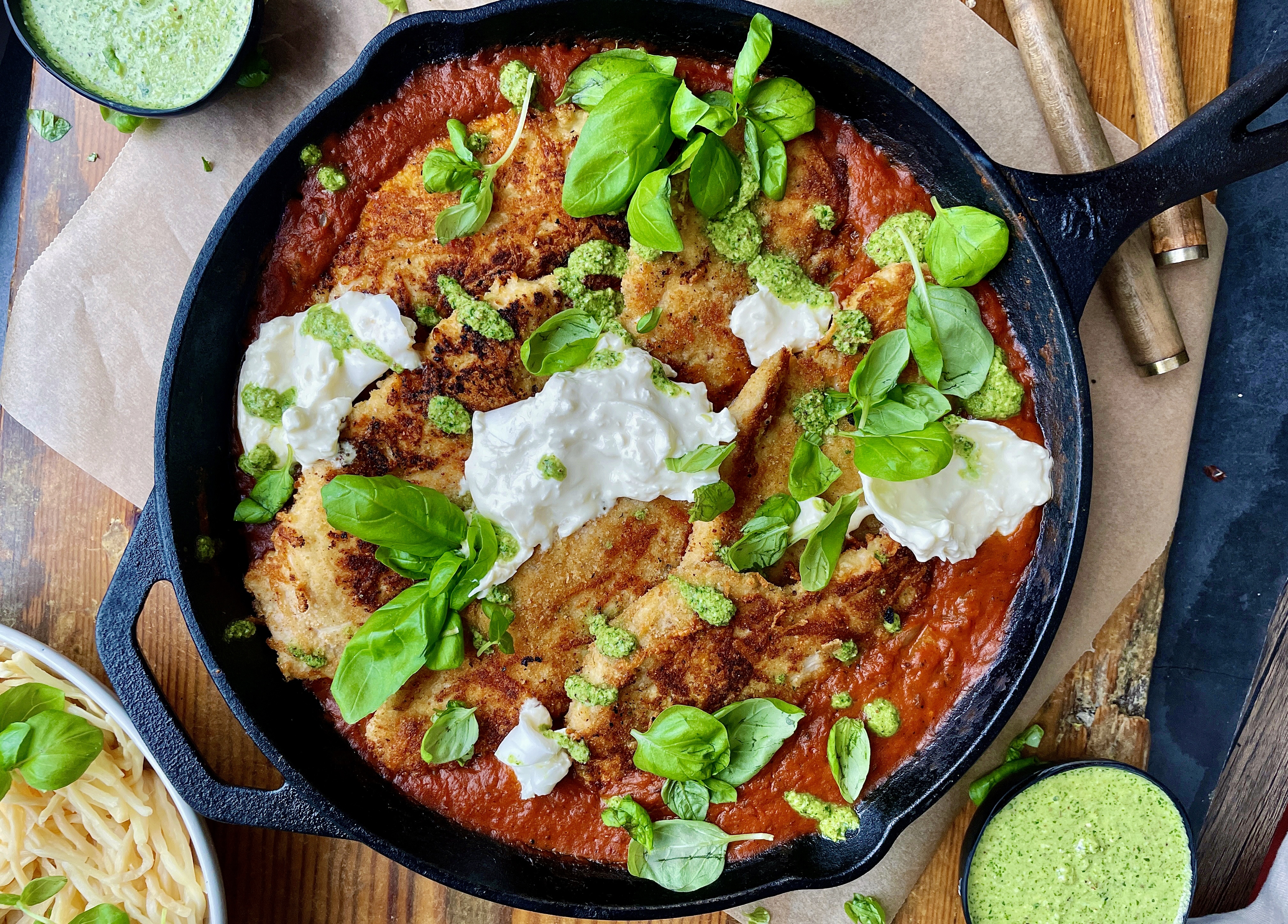 Crispy, lightly seared chicken breasts tucked into a lightened up vodka sauce all finished off in the oven and topped with creamy burrata and pesto: this Skillet Vodka Sauce Chicken Parmesan with Burrata is truly a death row meal.