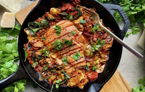 With tangy sun dried tomatoes and artichokes, all the spinach and garlic, and a lightened up creamy parmesan sauce: this Healthy Baked Tuscan Artichoke Salmon is the best cozy Italian dinner!