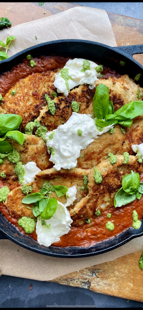 Crispy, lightly seared chicken breasts tucked into a lightened up vodka sauce all finished off in the oven and topped with creamy burrata and pesto: this Skillet Vodka Sauce Chicken Parmesan with Burrata is truly a death row meal. 