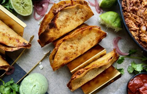 Homemade, golden crispy taco shells stuffed with adobo pulled chicken and jackfruit baked to perfection with all the melty cheese and dipped in a cooling avocado cilantro sauce: these Crispy Chicken and Jackfruit Tinga Tacos with Avocado Crema are truly a heavenly bite.