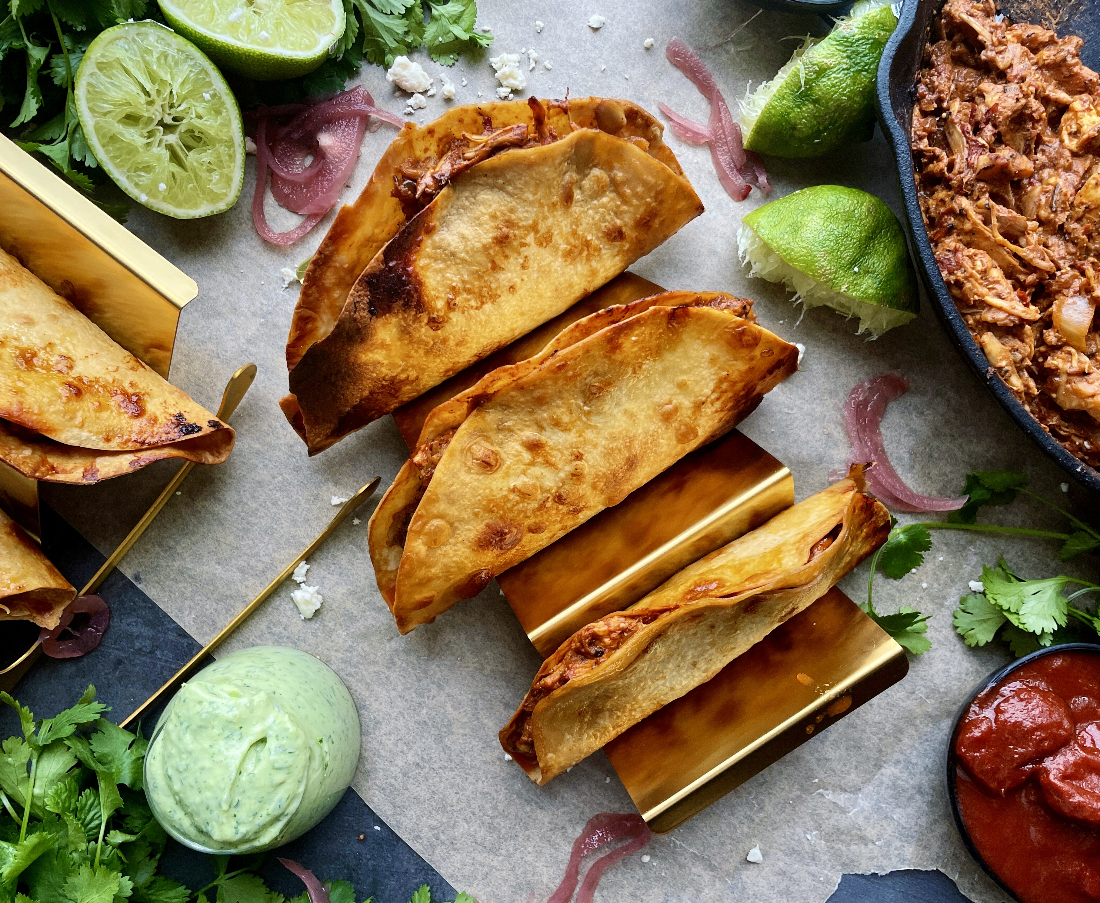 Homemade, golden crispy taco shells stuffed with adobo pulled chicken and jackfruit baked to perfection with all the melty cheese and dipped in a cooling avocado cilantro sauce: these Crispy Chicken and Jackfruit Tinga Tacos with Avocado Crema are truly a heavenly bite.