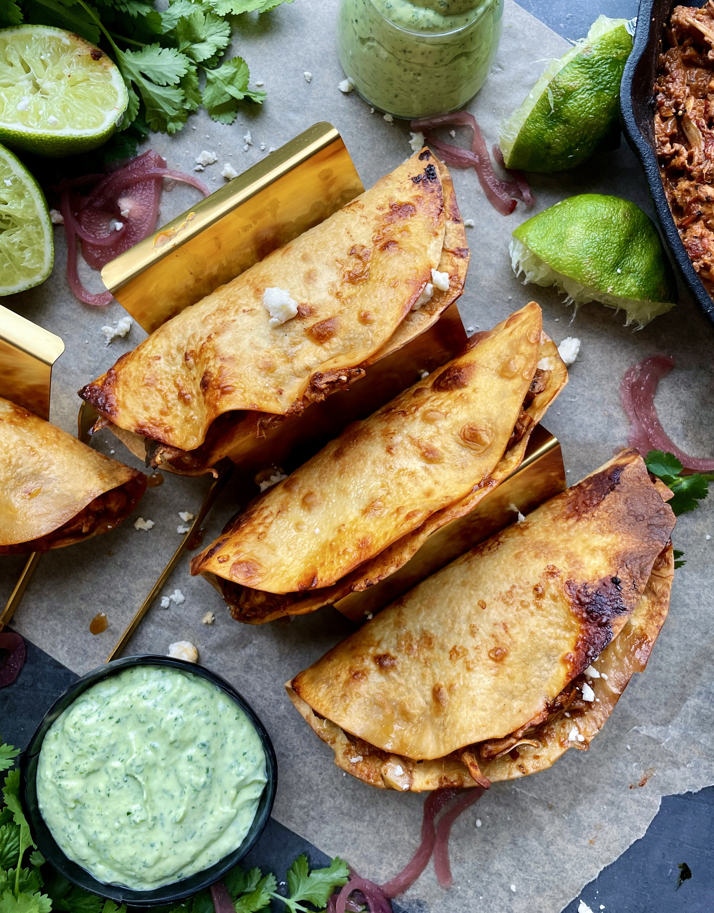  Homemade, golden crispy taco shells stuffed with adobo pulled chicken and jackfruit baked to perfection with all the melty cheese and dipped in a cooling avocado cilantro sauce: these Crispy Chicken and Jackfruit Tinga Tacos with Avocado Crema are truly a heavenly bite.