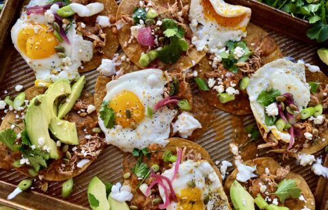 Crispy baked corn tortilla shells covered in the easiest smoky roasted salsa roja all topped off with fried eggs, cotija cheese, avocado, and all the bright flavors: these Baked Sheet Pan Tostada Chilaquiles are good any time of the day!!