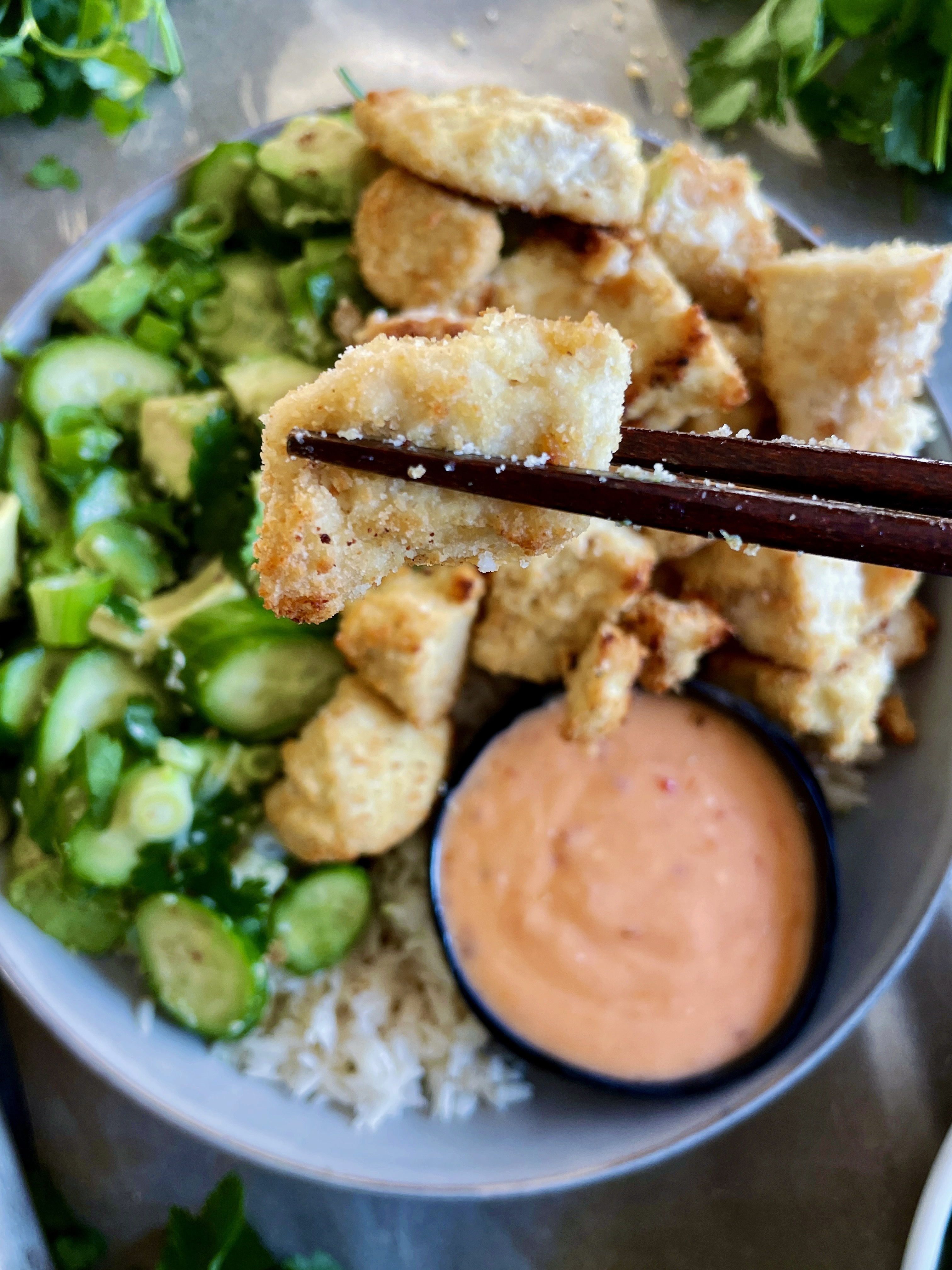 The crispiest oven roasted tofu clusters covered in the best ever sweet and spicy sauce and served alongside tangy marinated avocados and cucumbers: these Sweet Chili Crispy Torn Tofu Bowls recipe is truly the Asian bowl of my dreams!