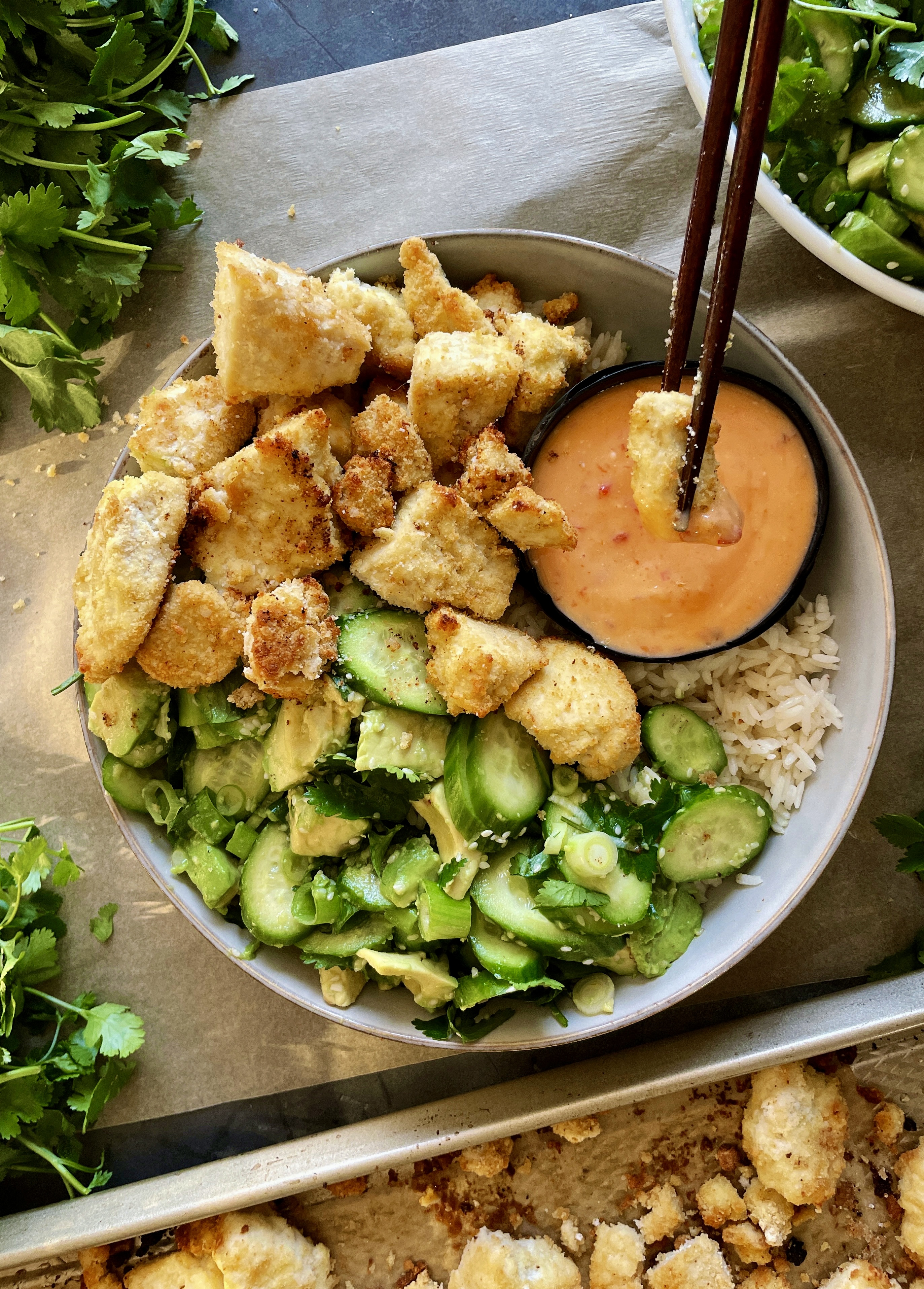 The crispiest oven roasted tofu clusters covered in the best ever sweet and spicy sauce and served alongside tangy marinated avocados and cucumbers: these Sweet Chili Crispy Torn Tofu Bowls recipe is truly the Asian bowl of my dreams!