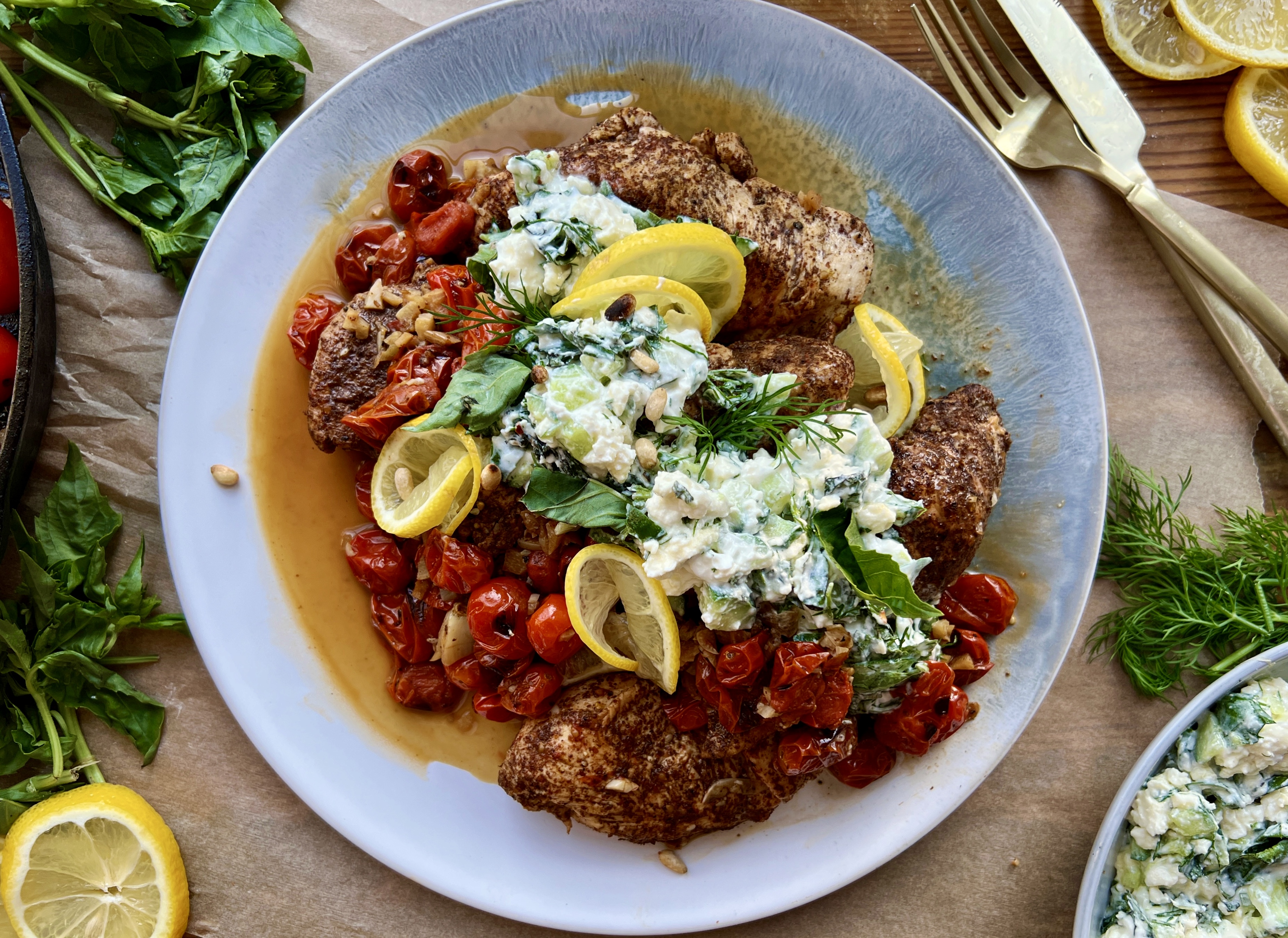 The easiest lemony sumac skillet chicken and tomatoes cooked down in garlicky white wine and finished with a cucumber mashed basil and mint feta: this Garlic Chicken with Roasted Tomatoes and Herbed Feta is truly my busy weeknight secret weapon.